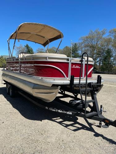 2025 Sun Tracker Party Barge 22 RF DLX pontoon boat on trailer, red with canopy.