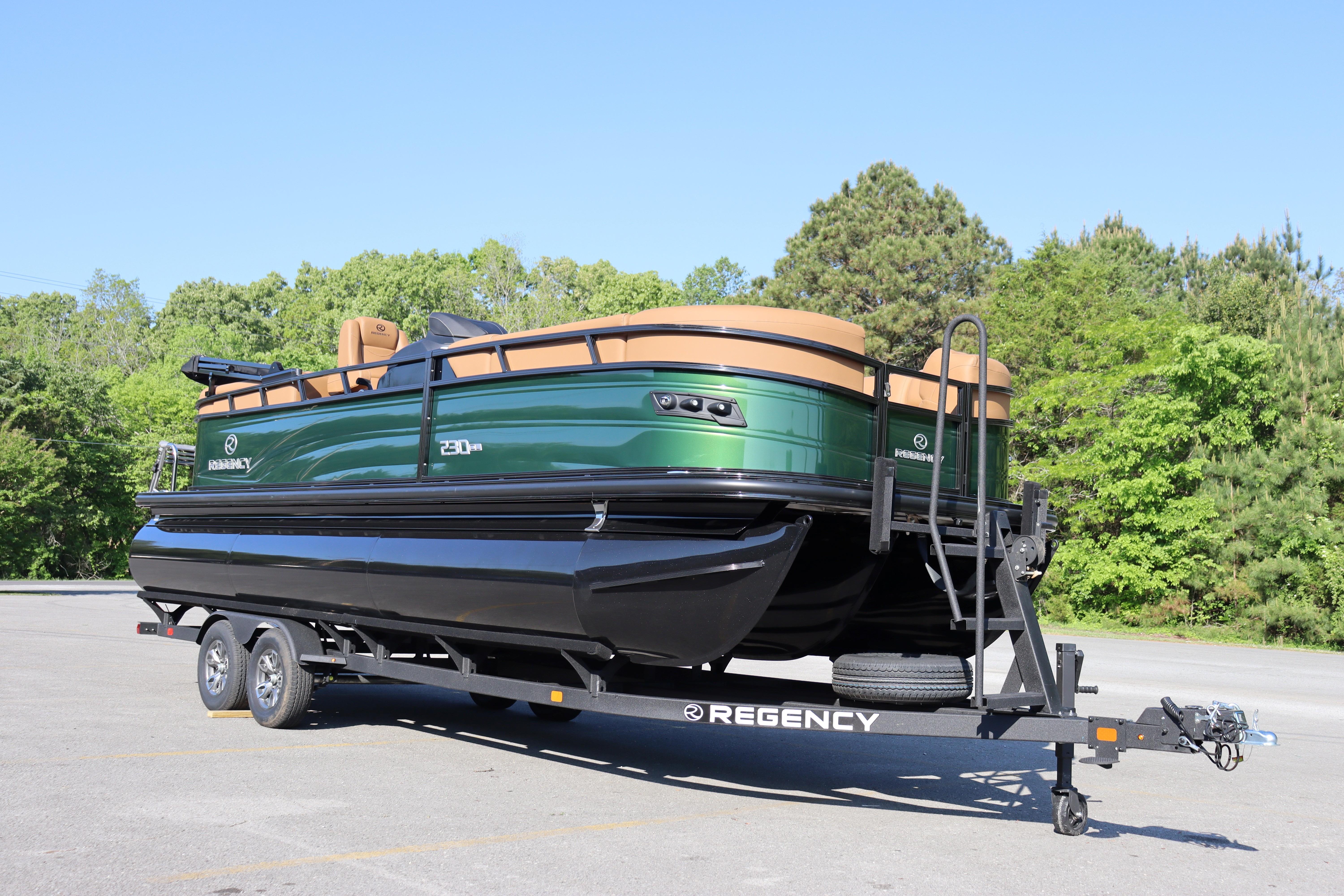 2026 Regency 230 DL pontoon boat on trailer, green and tan, parked outdoors.