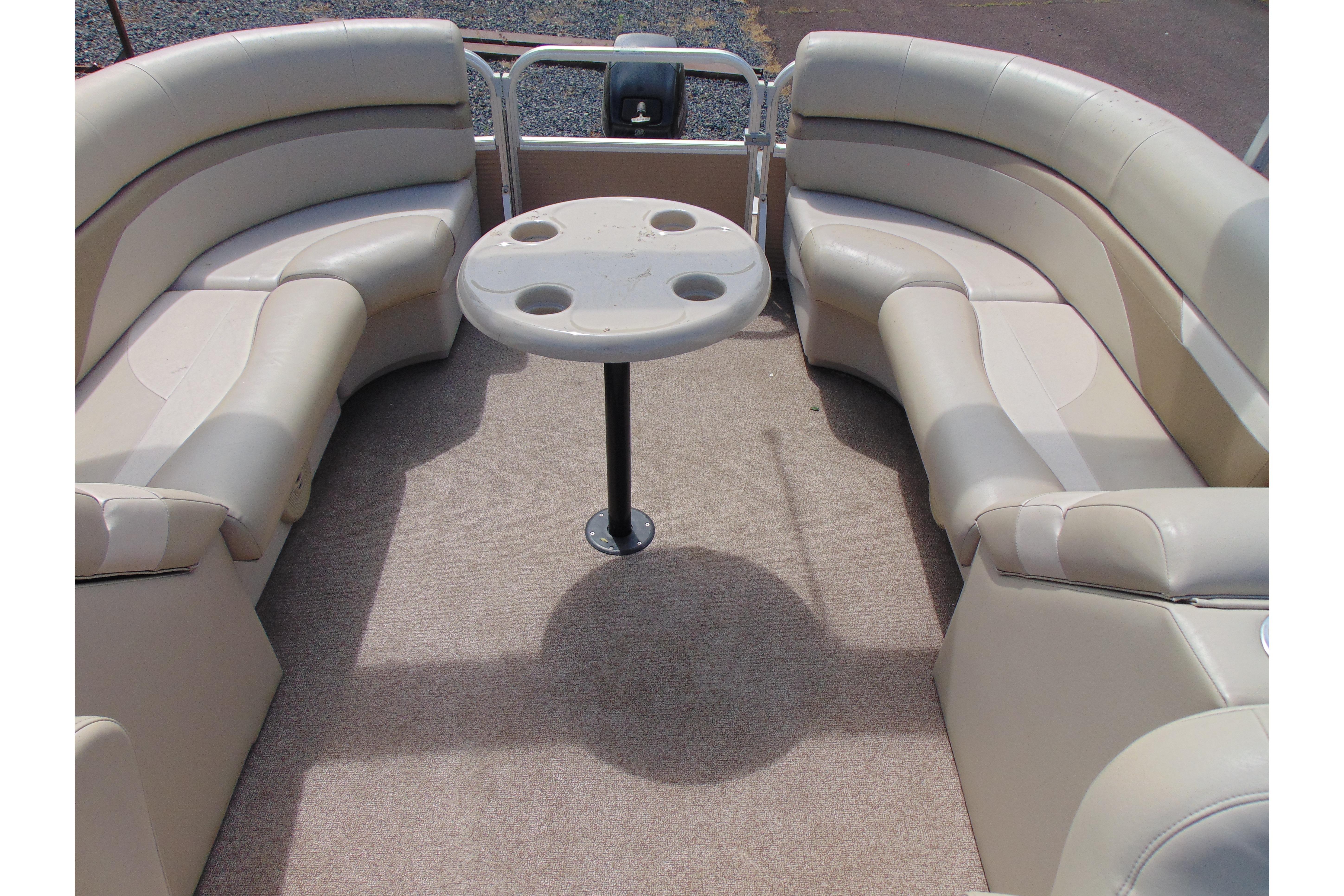 2016 Misty Harbor 245 Adventure CU boat interior with beige seating and round table.
