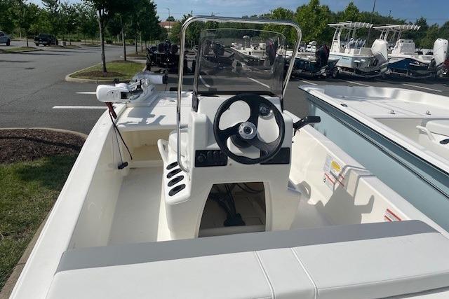 2026 Mako Pro Skiff 13 CC boat with steering console, parked outdoors.