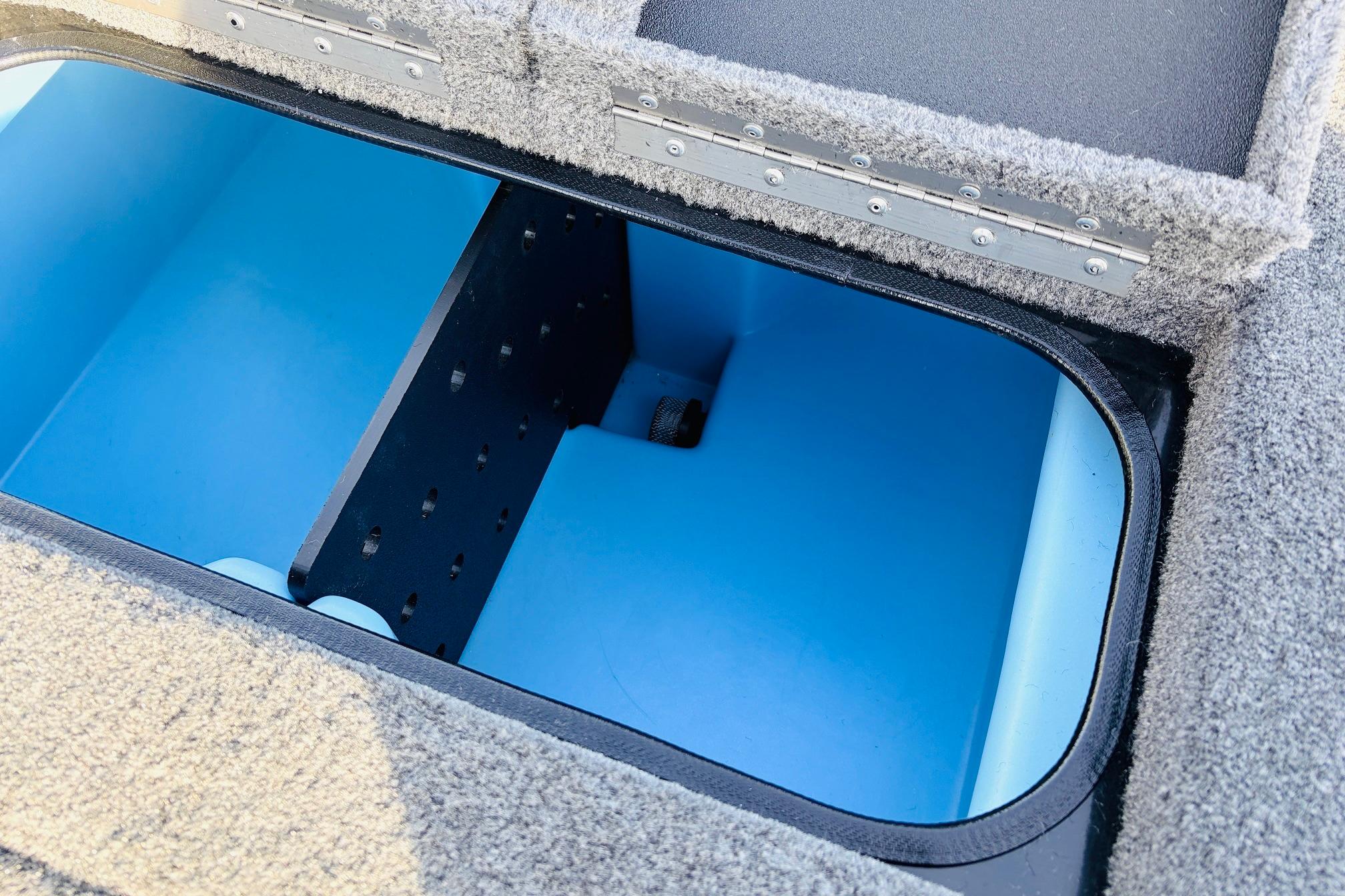 2025 Tracker Savage 215 boat storage compartment with blue interior and carpeted edges.