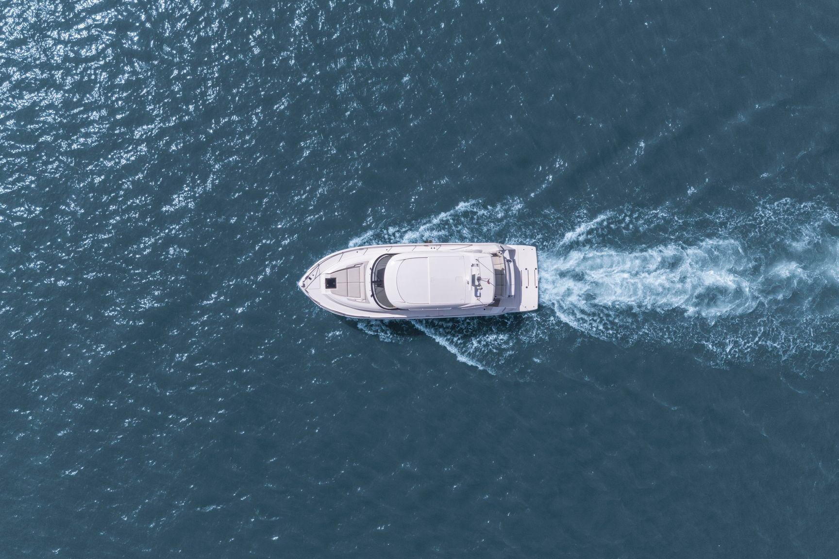 Aerial view of 2023 Tiara Yachts C49 Coupe cruising on open water.