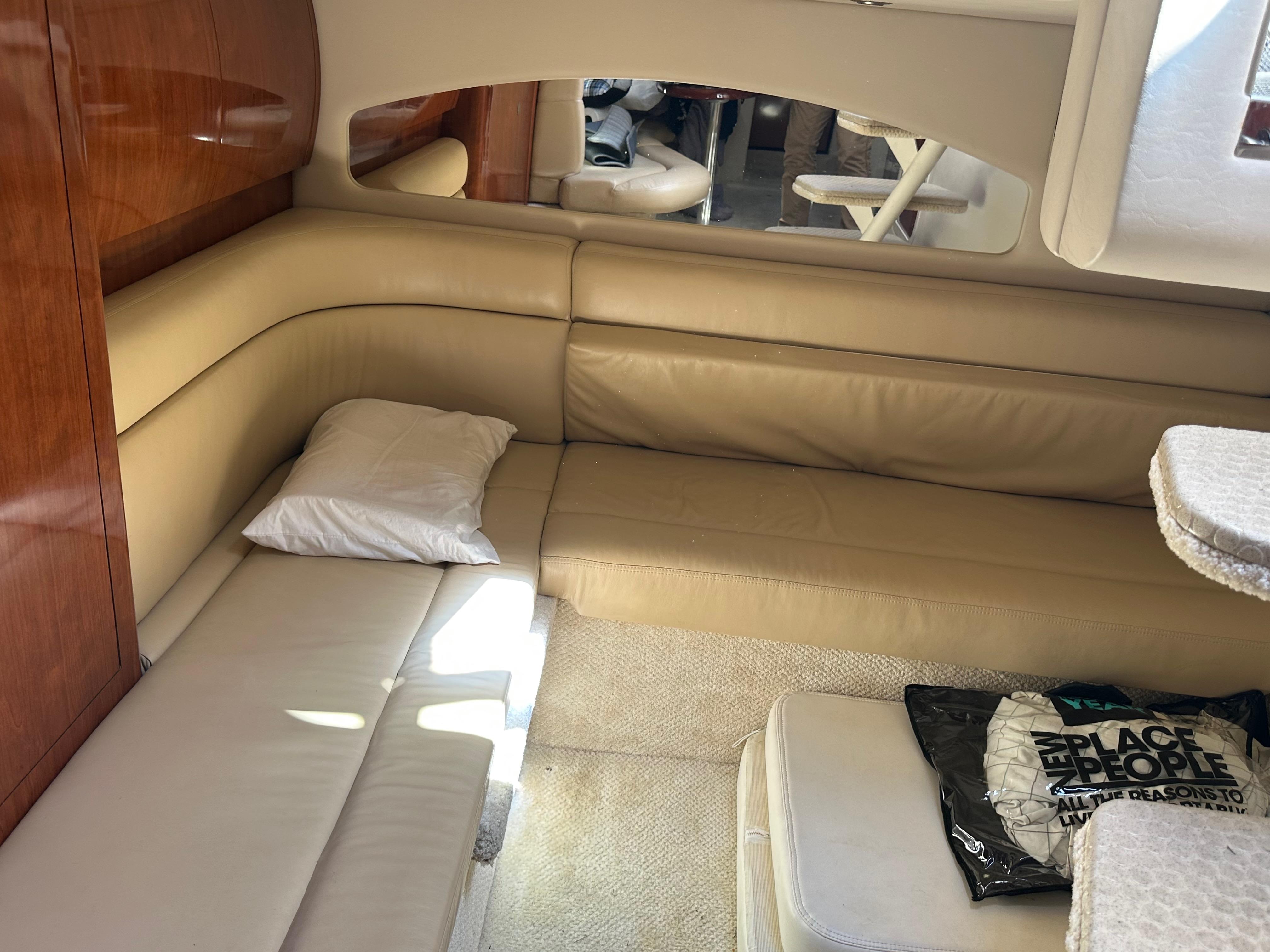 2004 Sea Ray 360 Sundancer interior with beige seating and wooden accents.