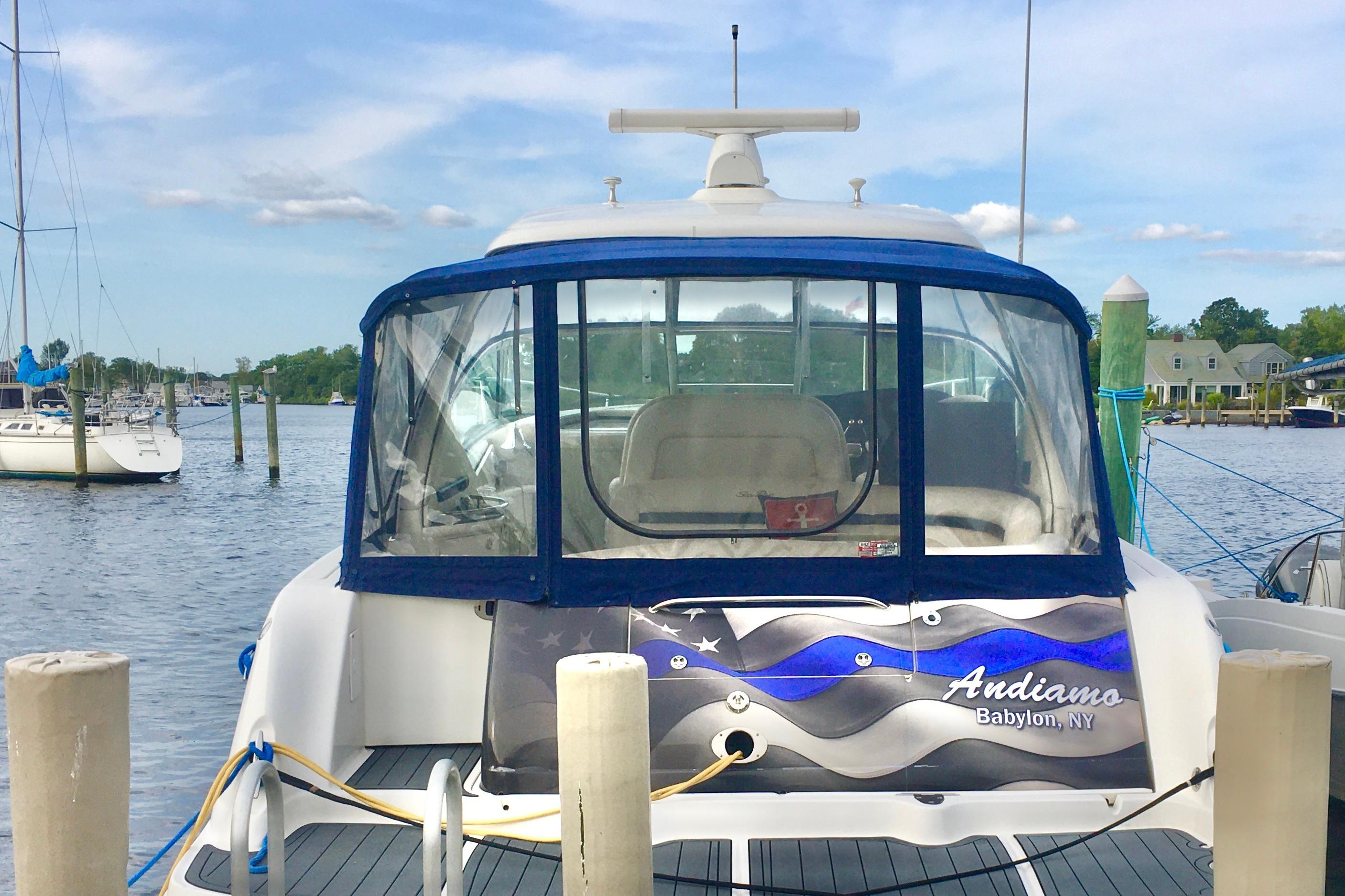 2005 Sea Ray 420 Sundancer docked at a marina, featuring a blue canopy.