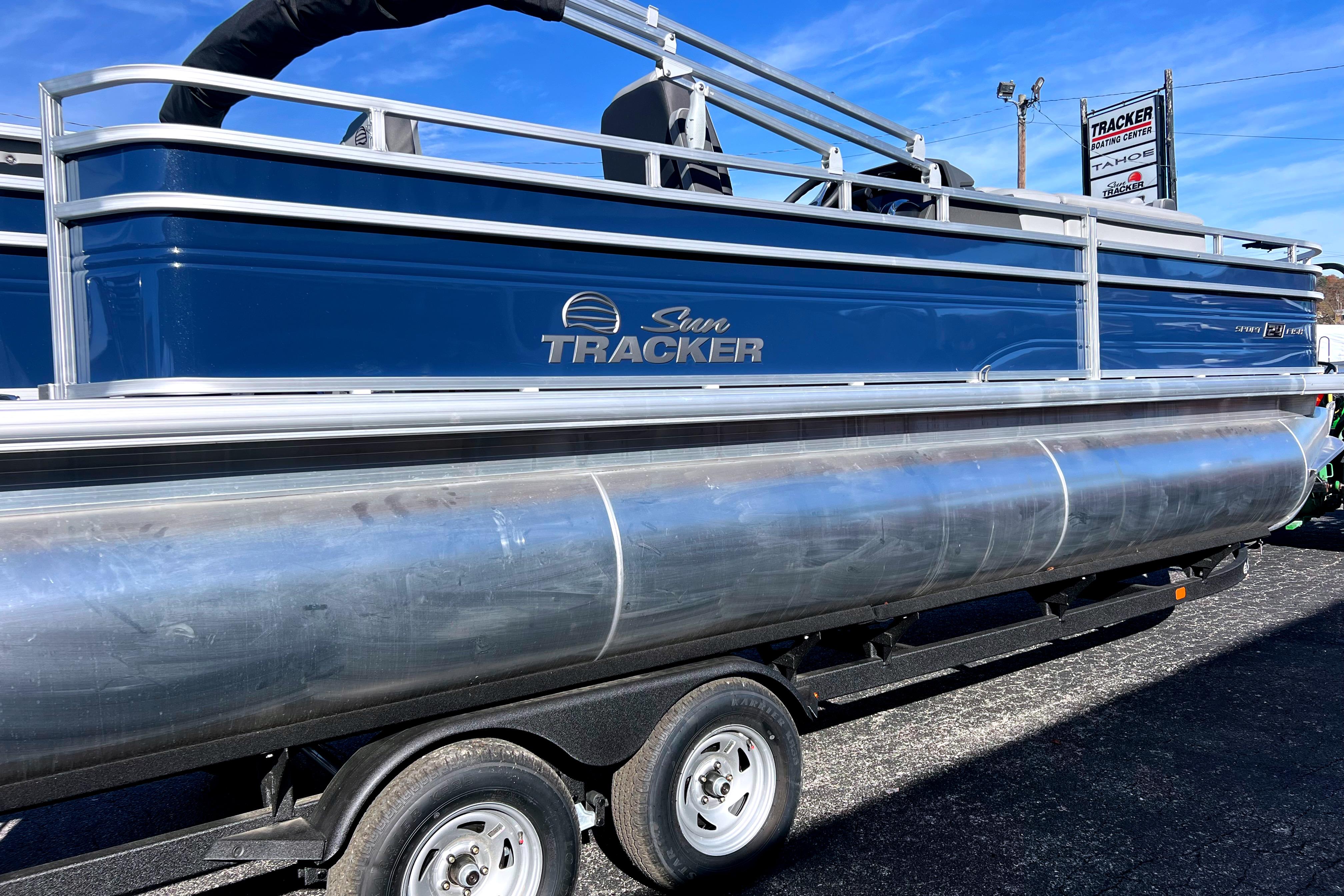 2026 Sun Tracker Sportfish 24 XP3 pontoon boat on trailer, blue exterior.