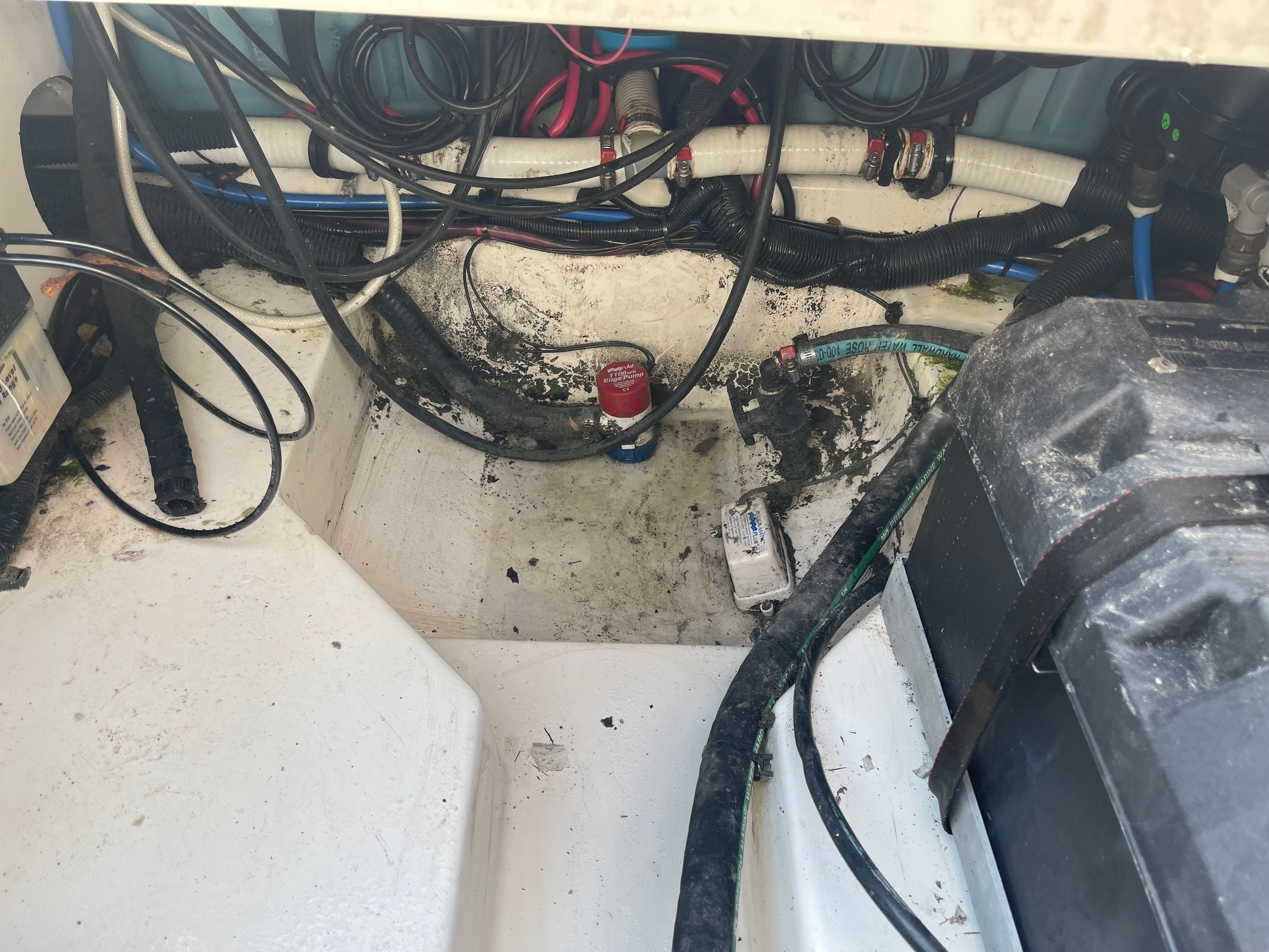 Interior of a 2001 Boston Whaler 26 Conquest boat with cables and battery.