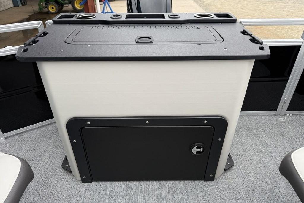 2026 Sun Tracker Fishin' Barge 20 DLX fishing station with storage and measuring board.