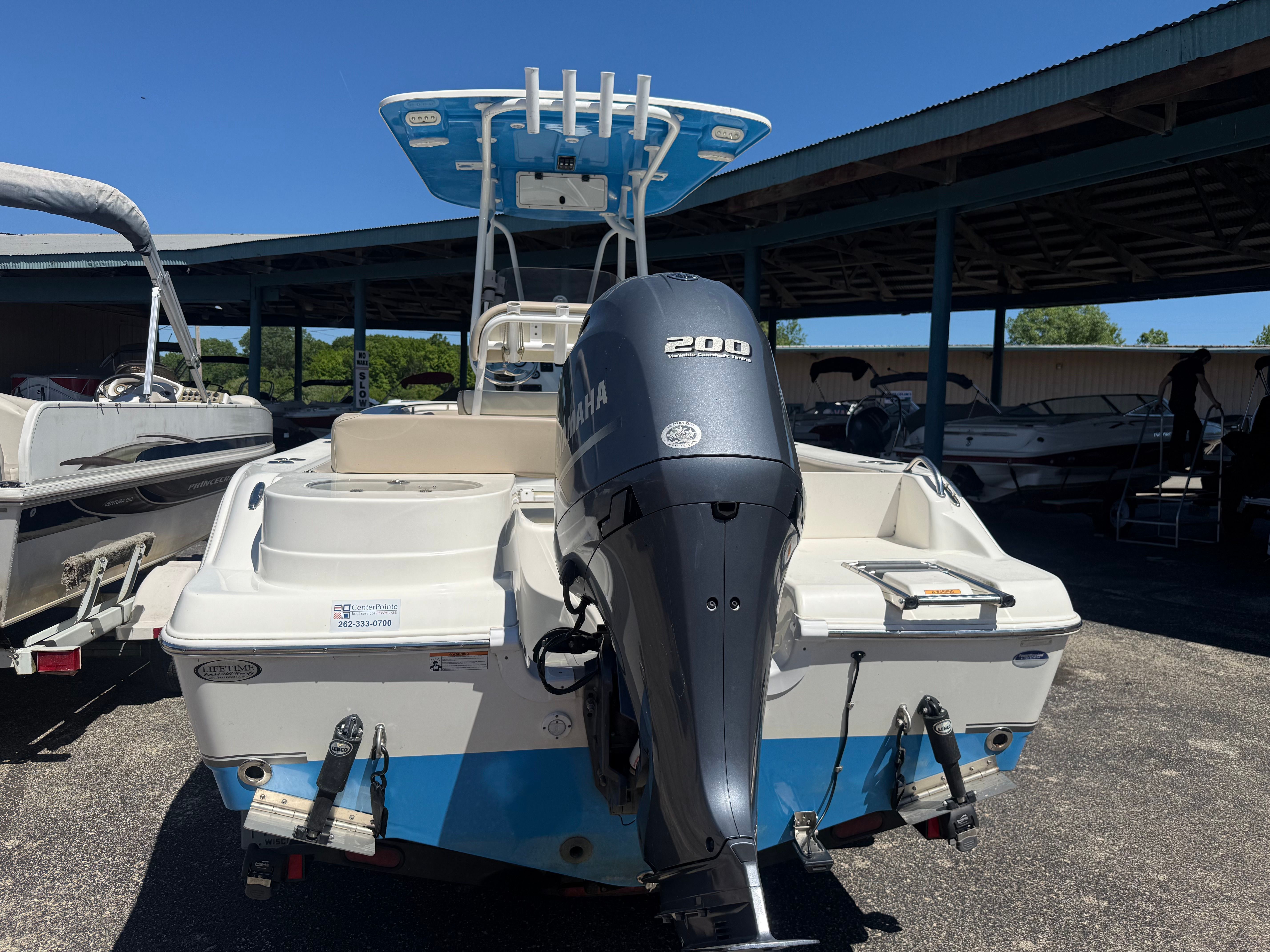 A NauticStar 22 XS boat with a Yamaha 200 engine is parked in a lot.