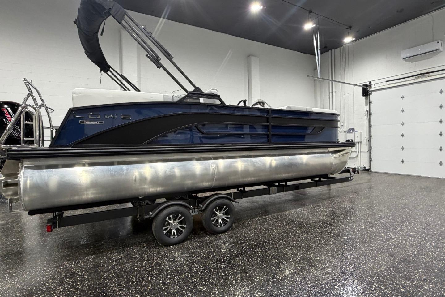 2026 Lowe SS 230 WT pontoon boat on trailer in indoor showroom.