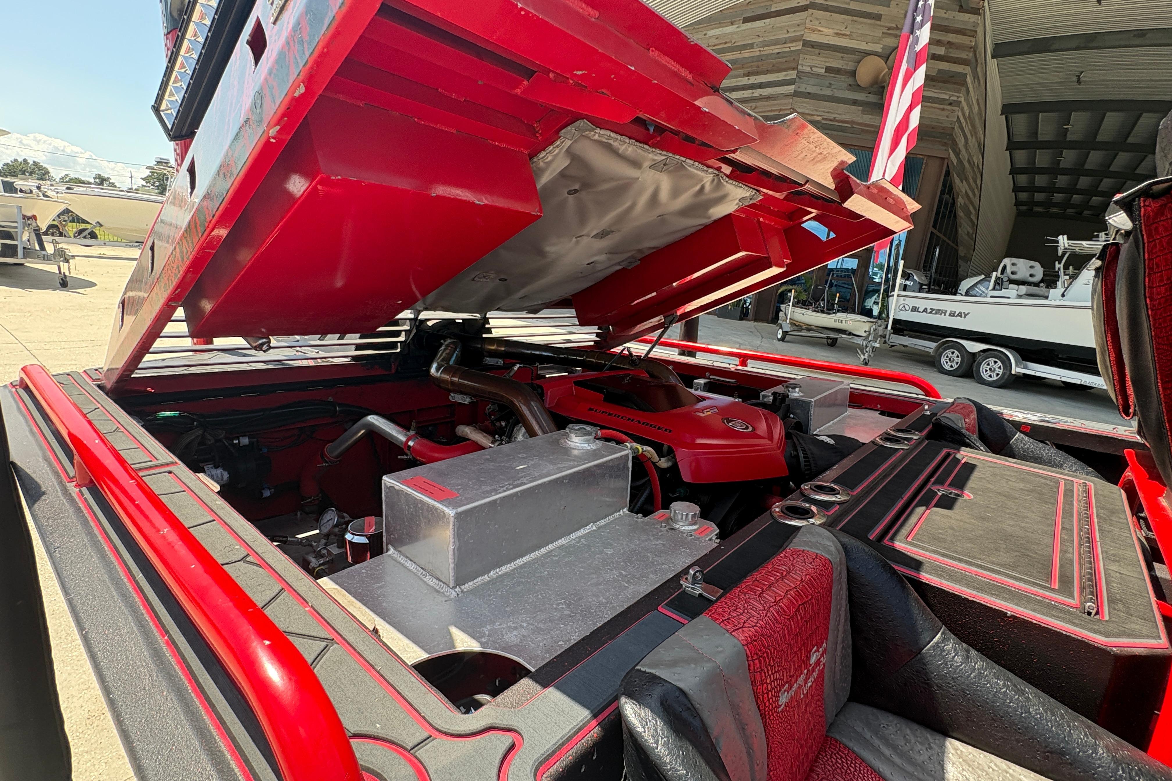Open engine compartment of a 2018 Custom Swamp Shark 24' boat, showcasing red detailing.