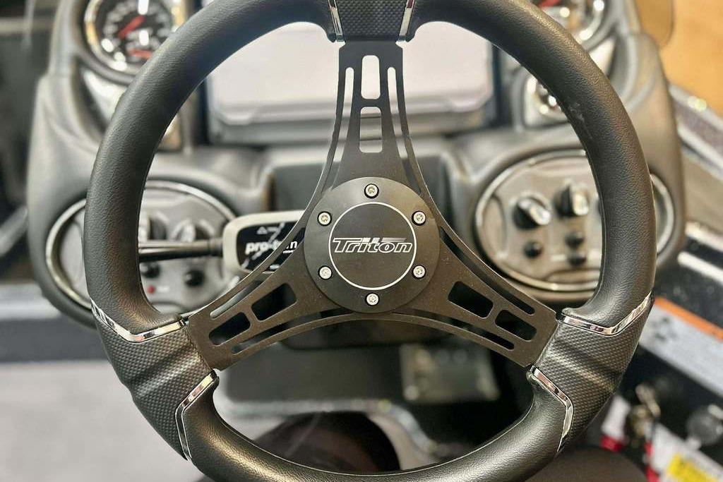 Steering wheel of 2026 Triton 18 TrX boat, featuring sleek design and controls.