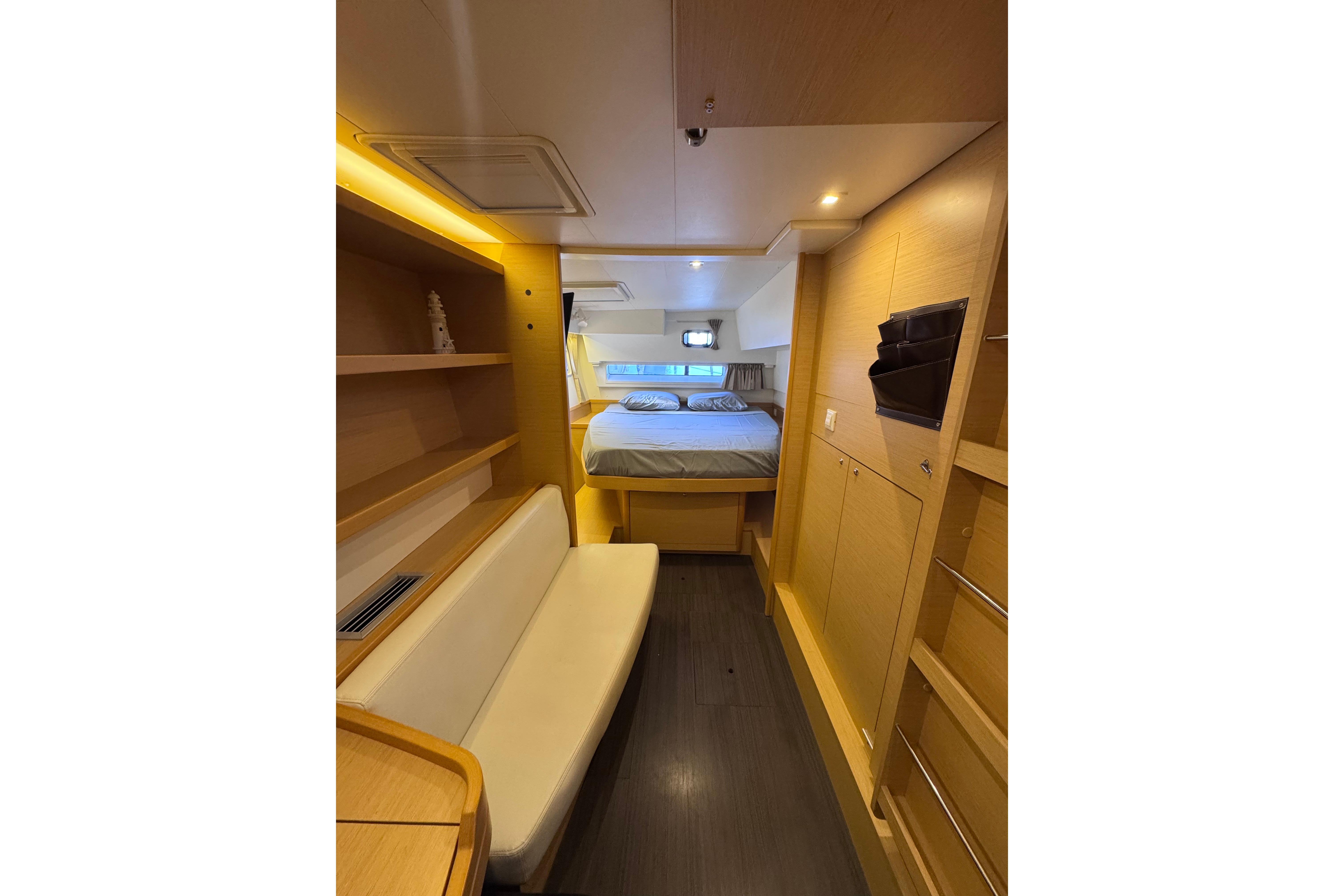 Interior of 2018 Lagoon 42 yacht, featuring cozy cabin with bed and seating area.
