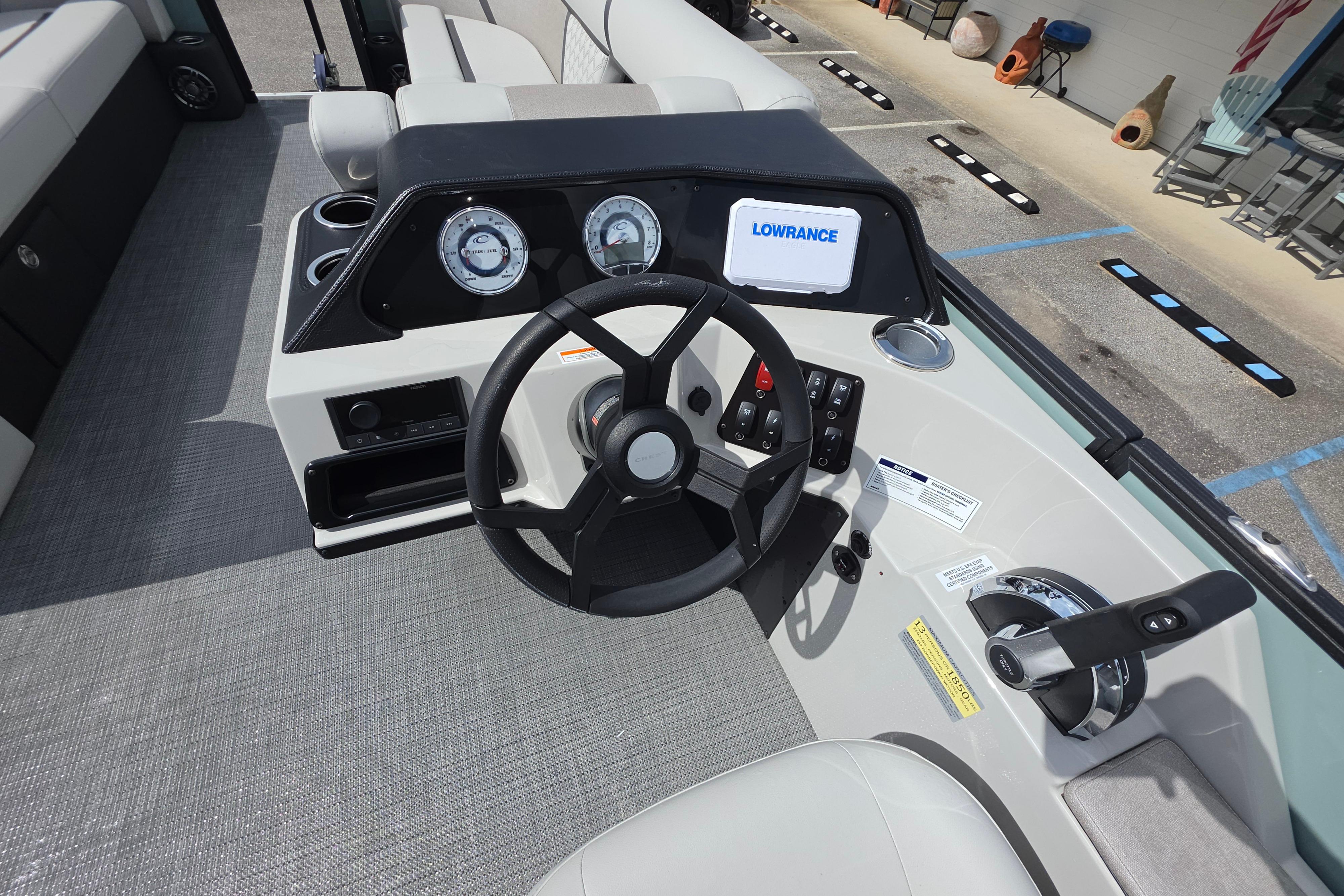 2026 Crest 235 Conquest SLC boat dashboard with steering wheel and Lowrance display.