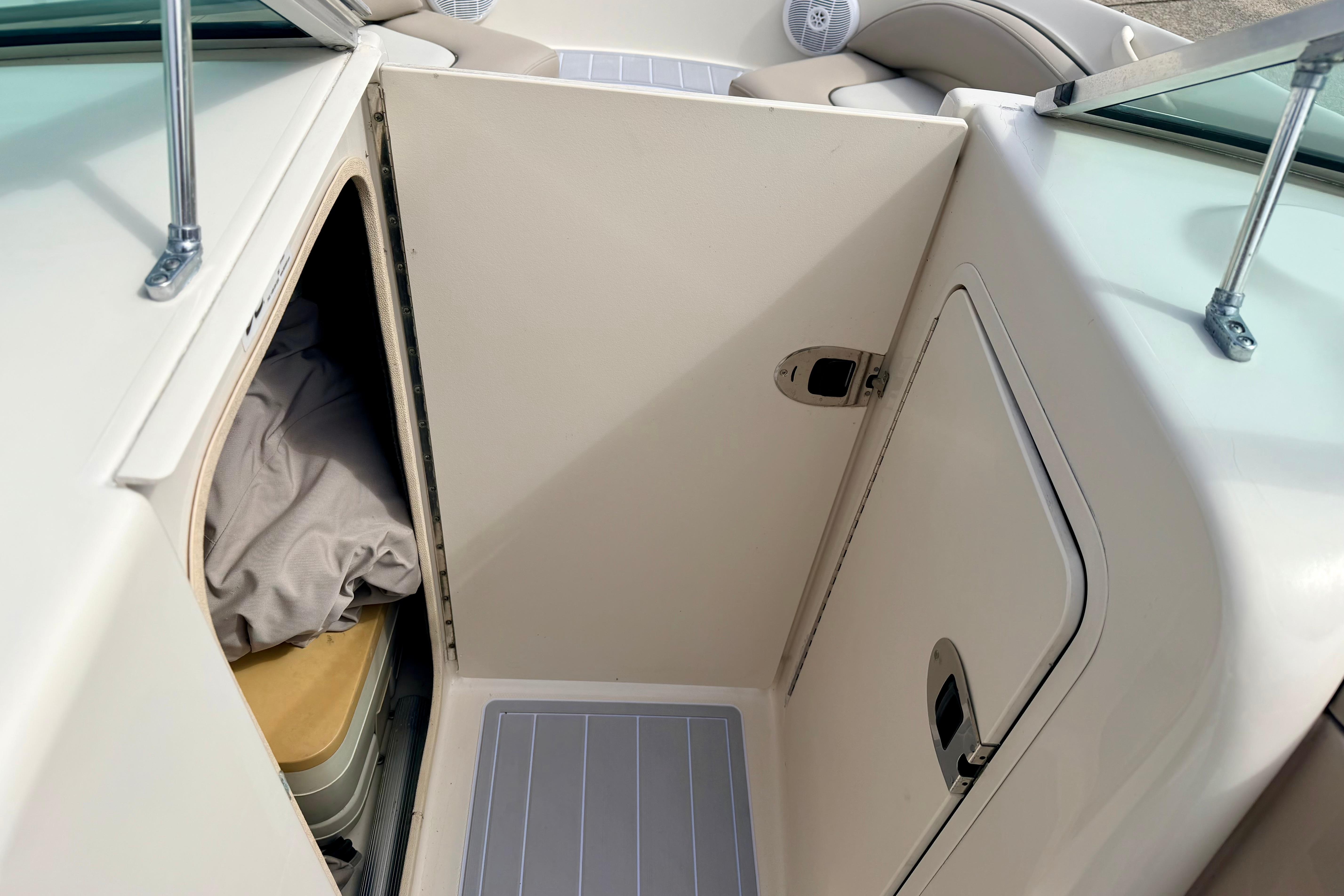 2003 Sea Ray 200 Sundeck interior storage compartment with door and cushion.