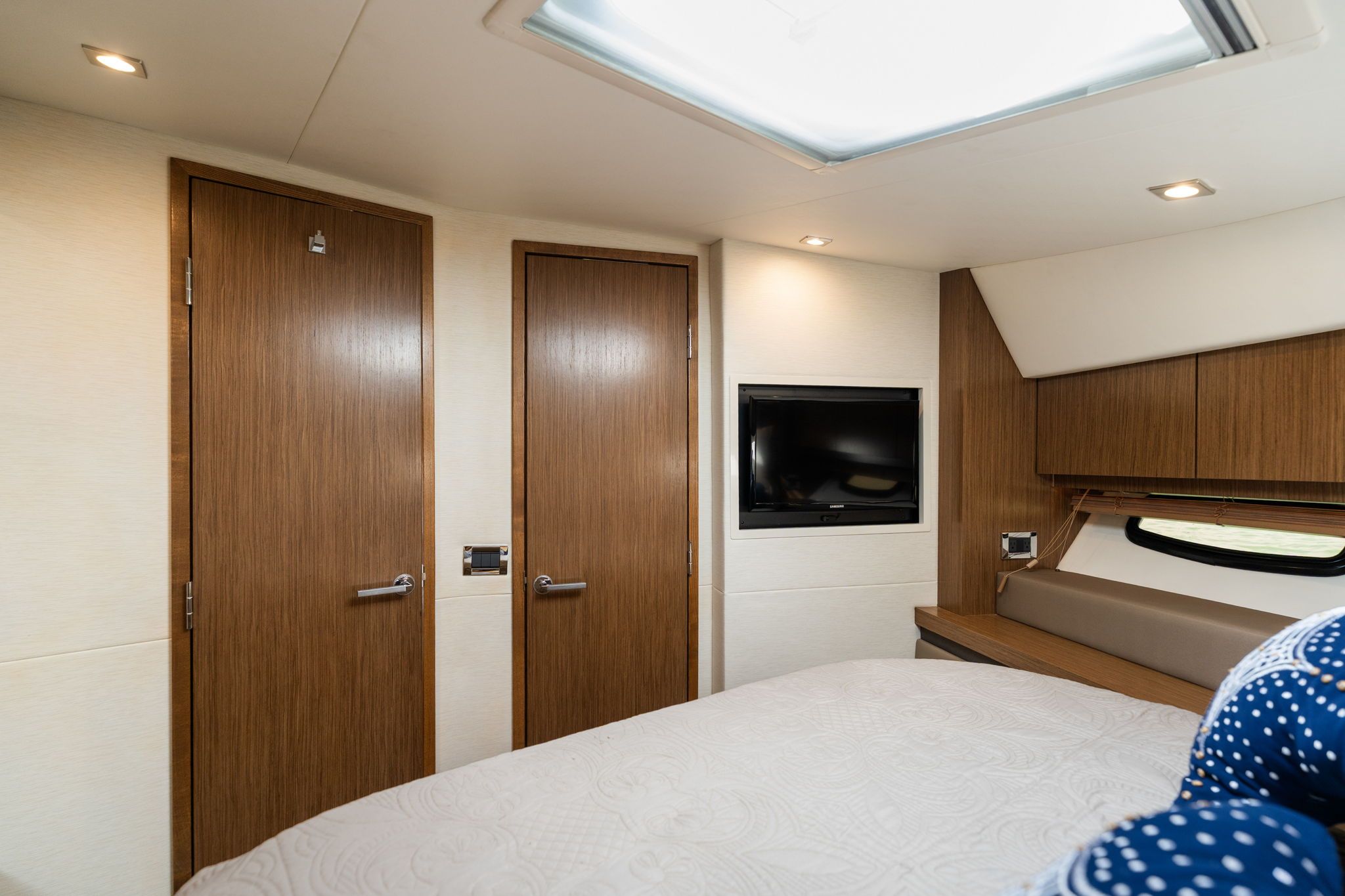 Interior of a 2017 Sea Ray Sundancer 510 with wooden doors and a flat-screen TV.