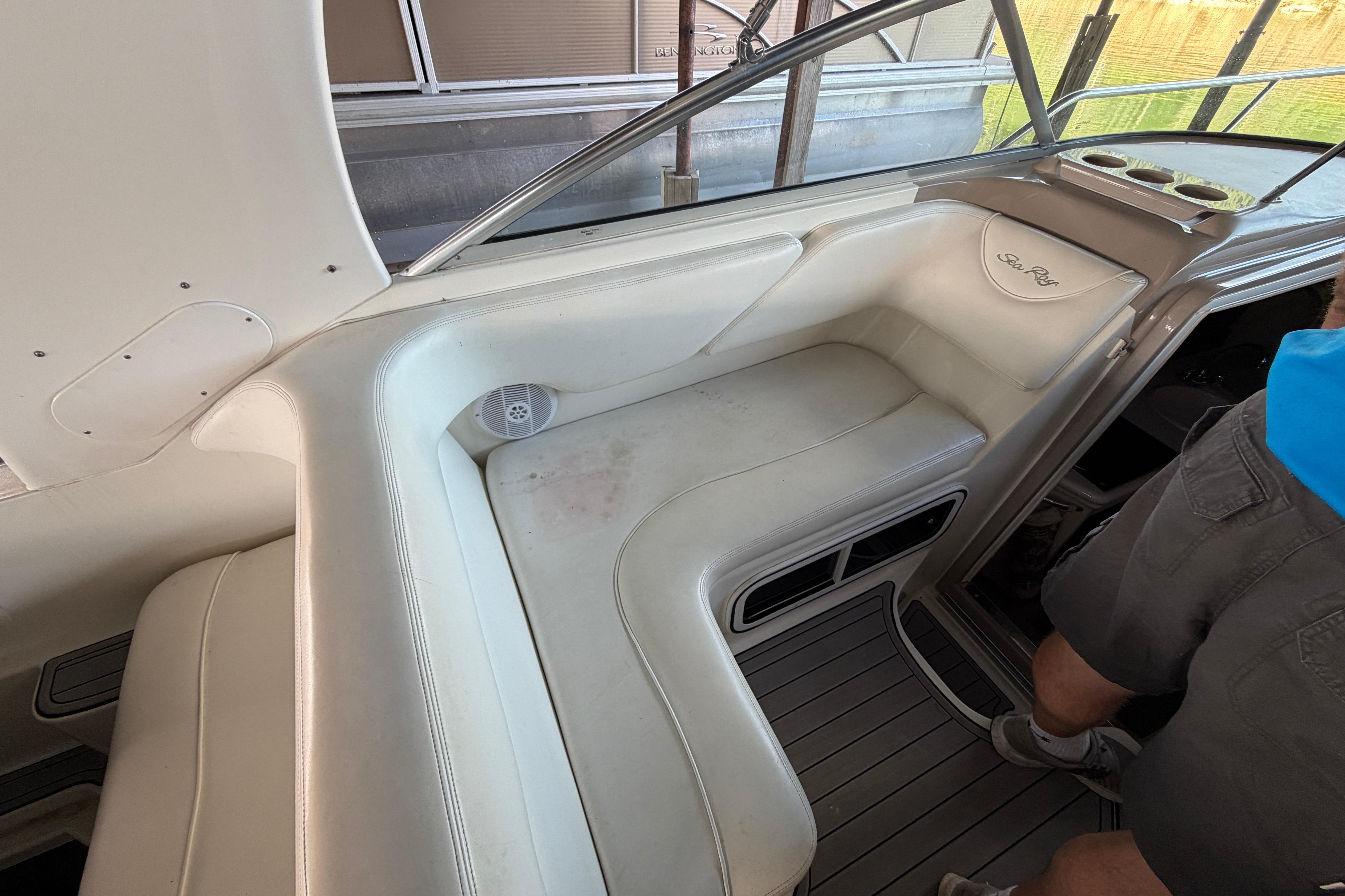 Interior seating of a 2004 Sea Ray Sundancer 260 boat with white upholstery.