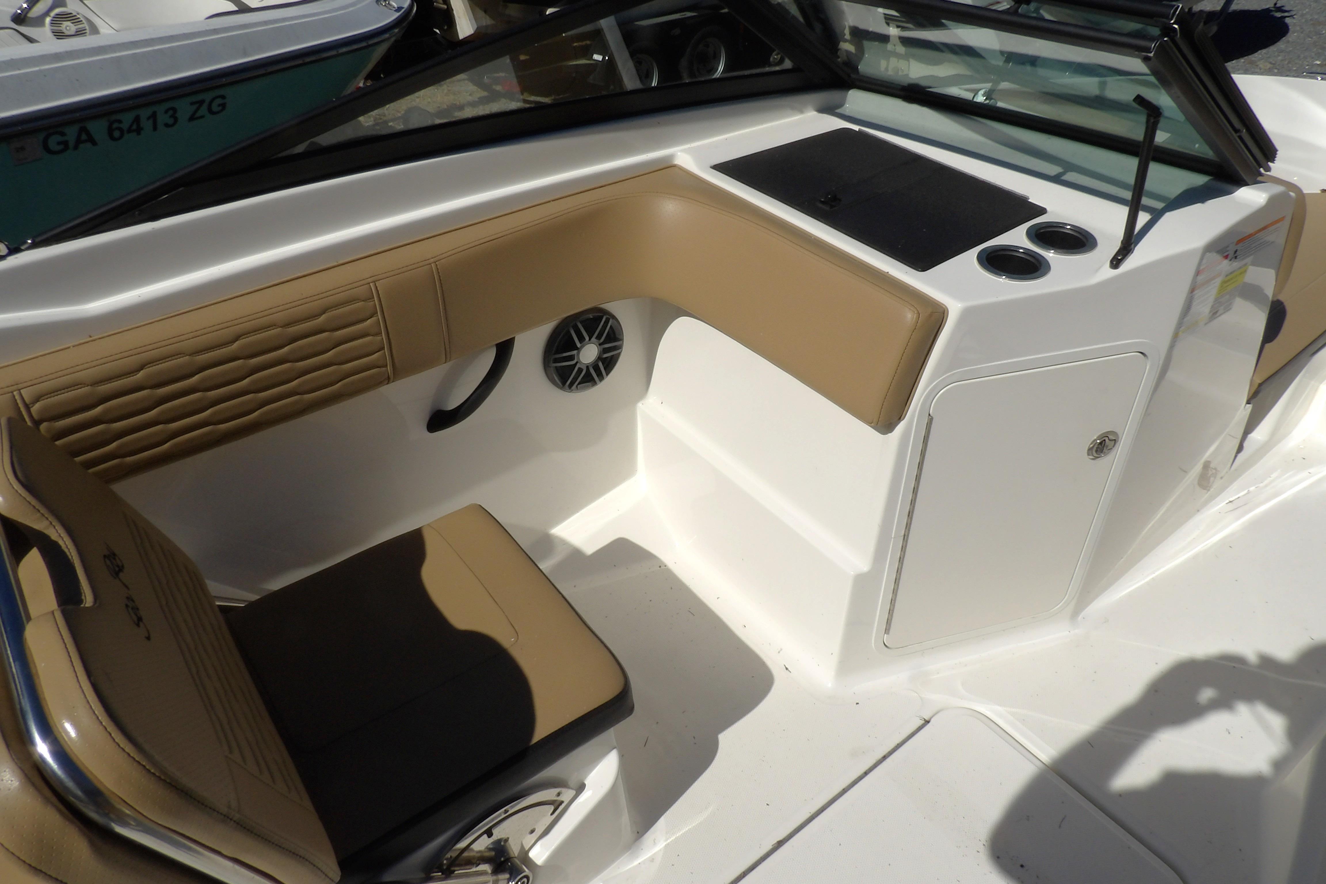 2023 Searay 210 SPO boat interior with tan seating and storage compartment.