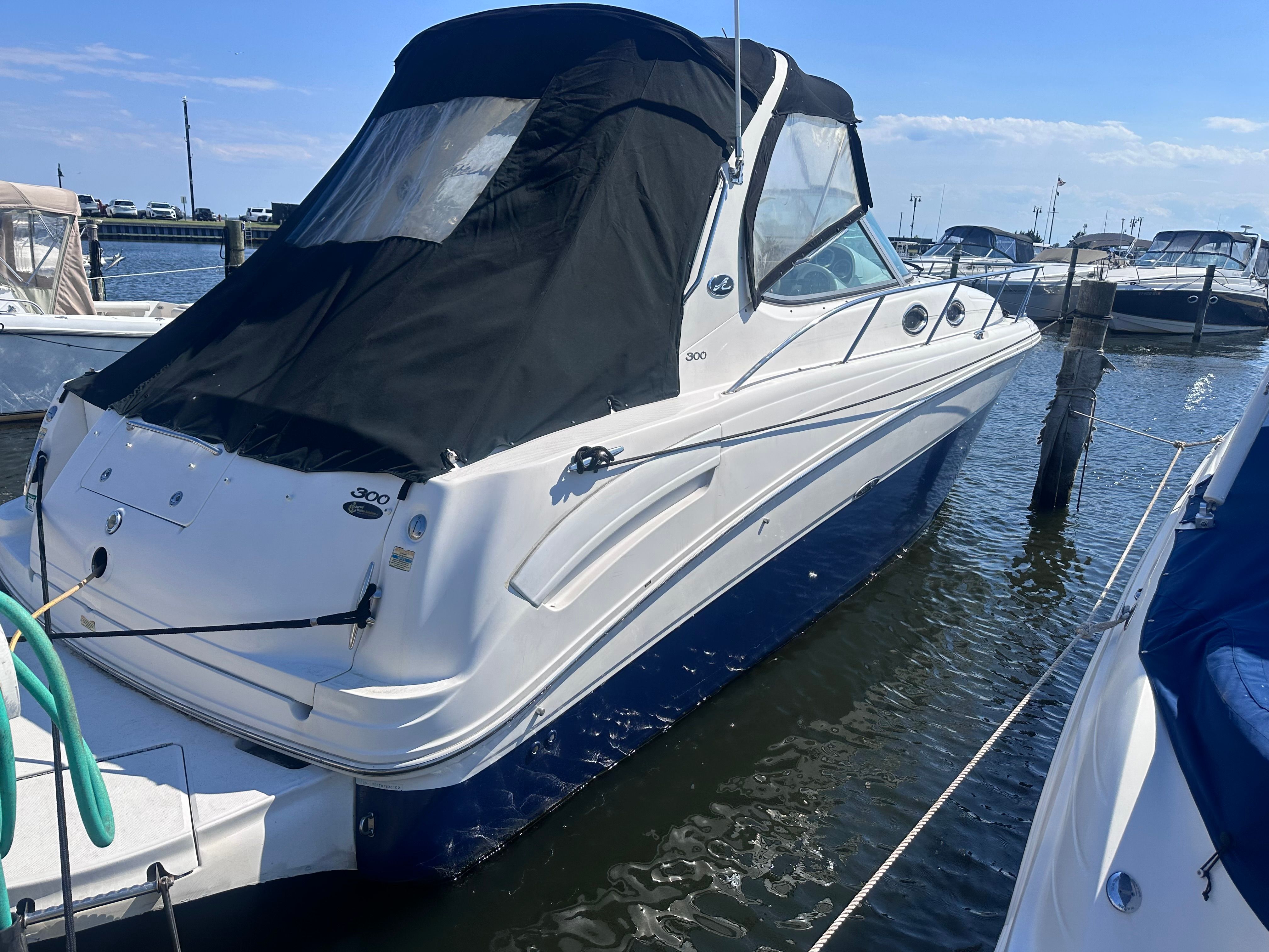 A 2002 Sea Ray 300 Sundancer is docked in the water.