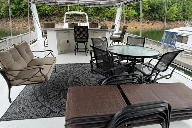 Spacious deck of 1997 Stardust Houseboat 18x83 with outdoor seating and dining area.