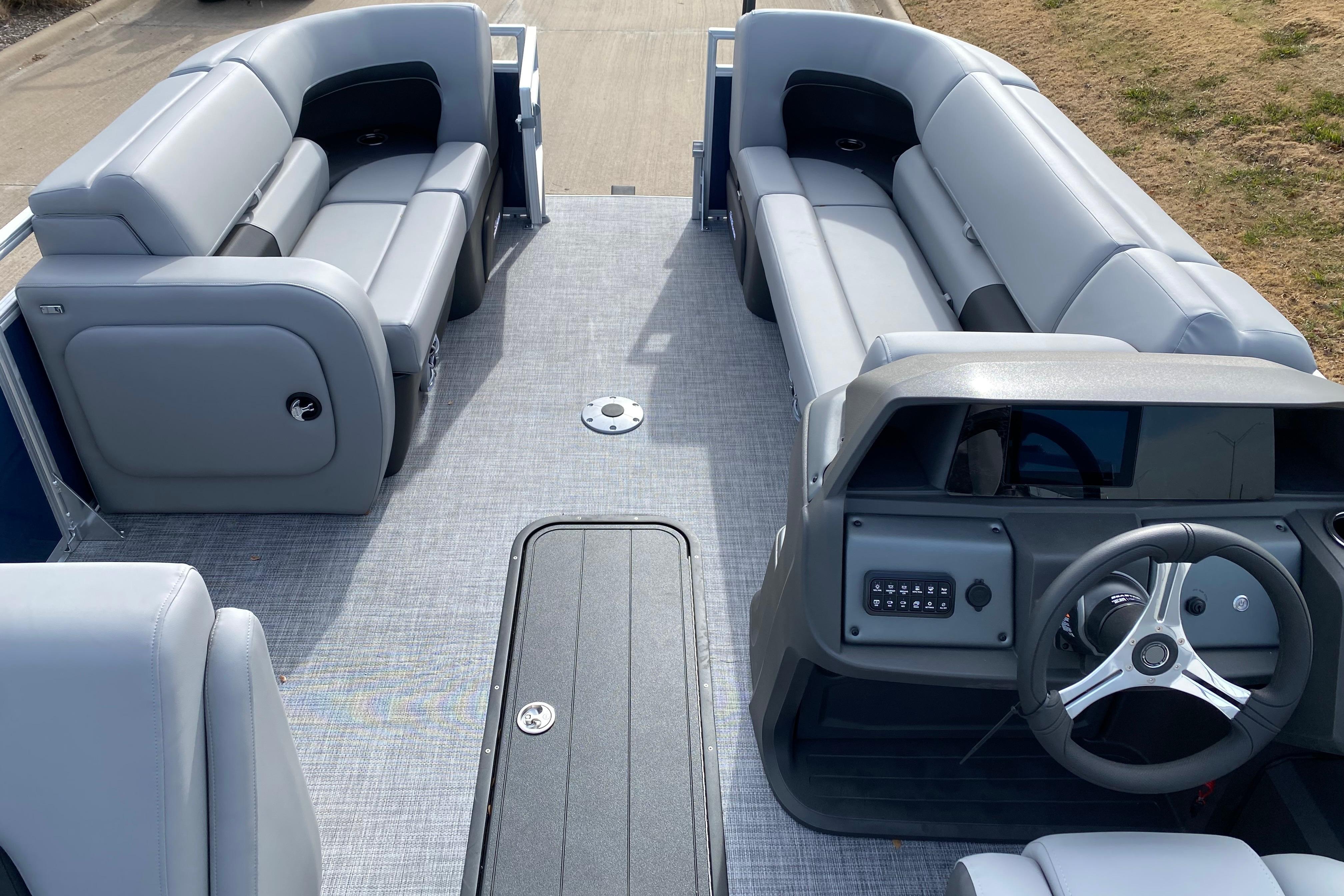 2026 Sun Tracker SportFish 22 XP3 pontoon boat interior with gray seating and steering console.