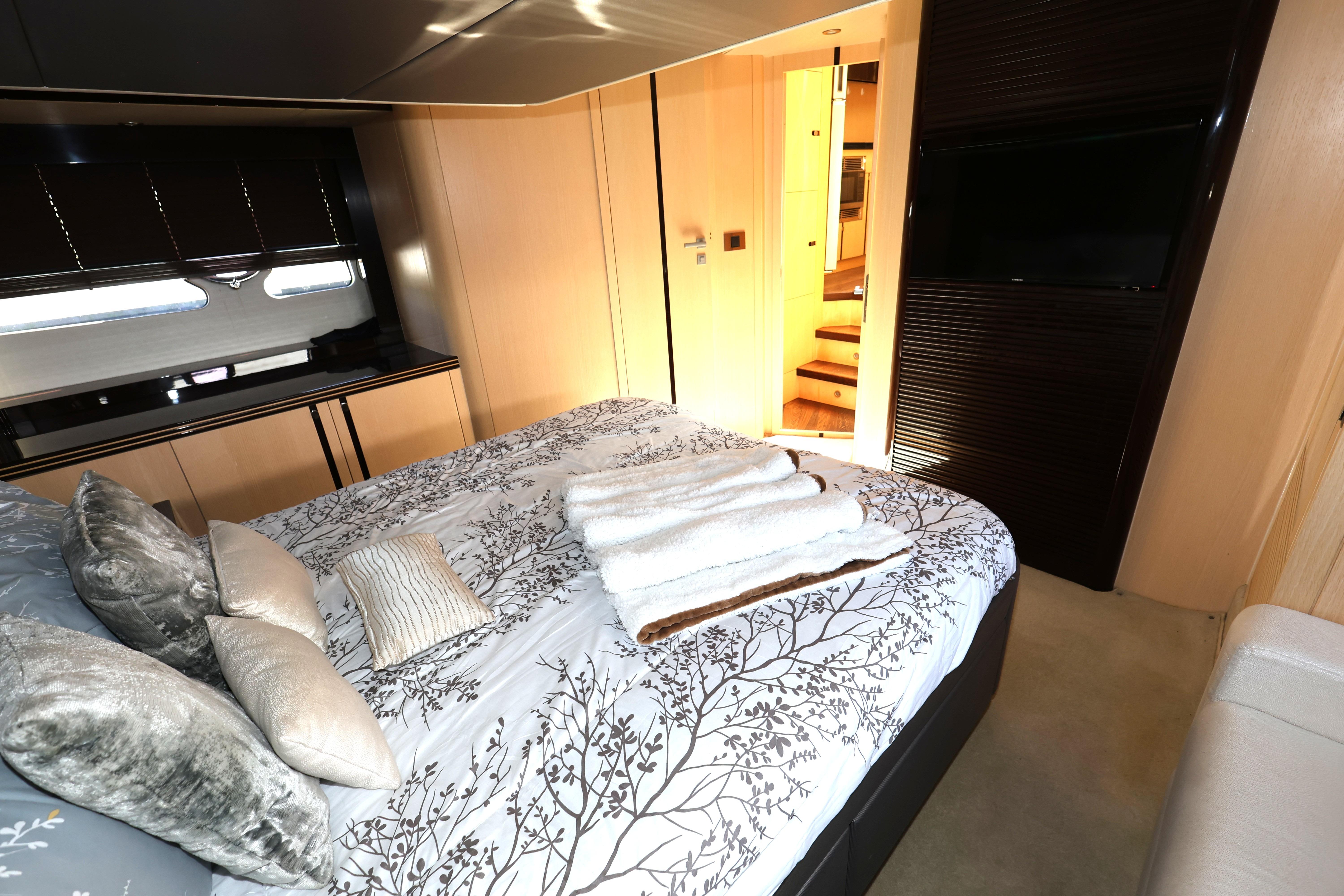 Luxurious bedroom interior of 2016 Sunseeker Manhattan 55 yacht with elegant bedding and modern decor.