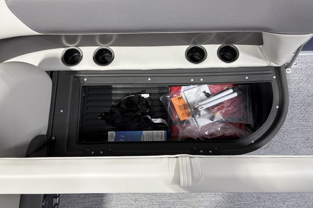Storage compartment in 2026 Sun Tracker Bass Buggy 18 DLX, containing various boating accessories.