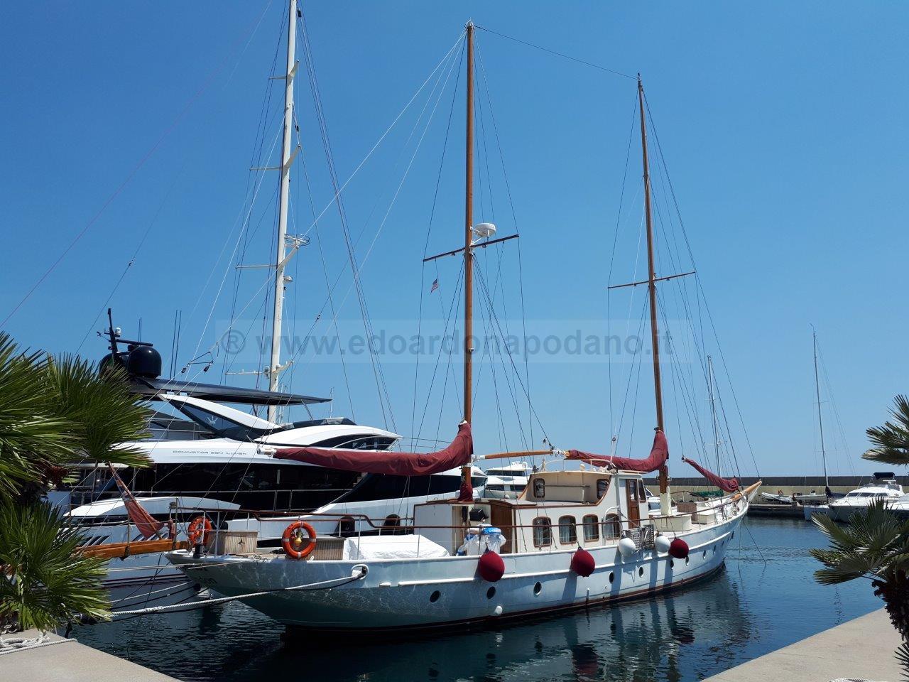 Vintage 1932 De Vries Lentsch schooner docked in a sunny marina.