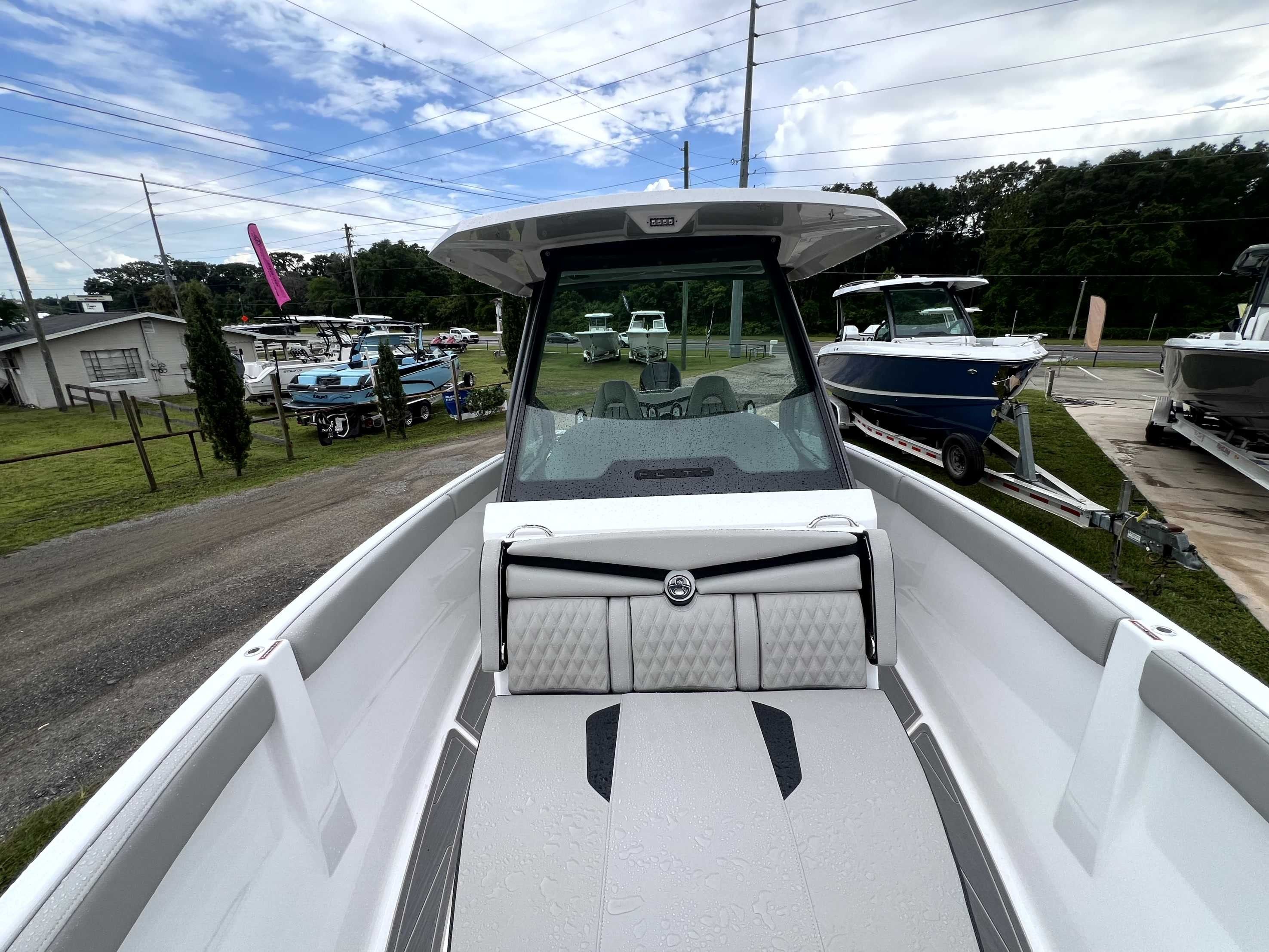 The image shows a modern boat with sleek design and cushioned seating.
