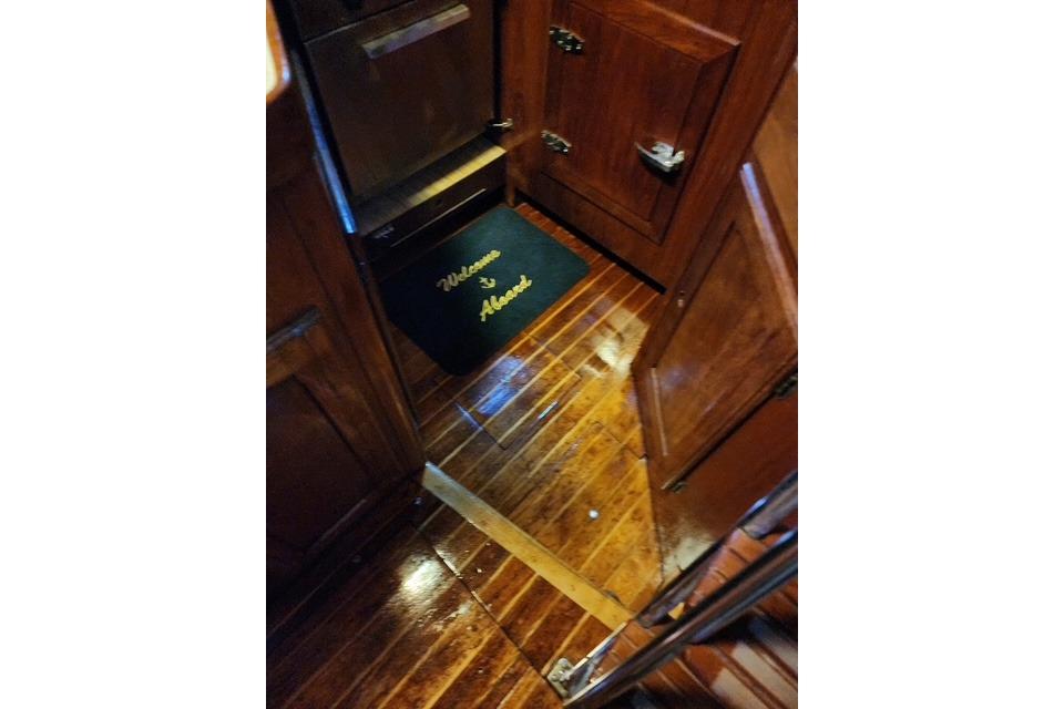 Interior of 1984 Bristol 45.5 Center Cockpit with polished wood flooring and welcome mat.