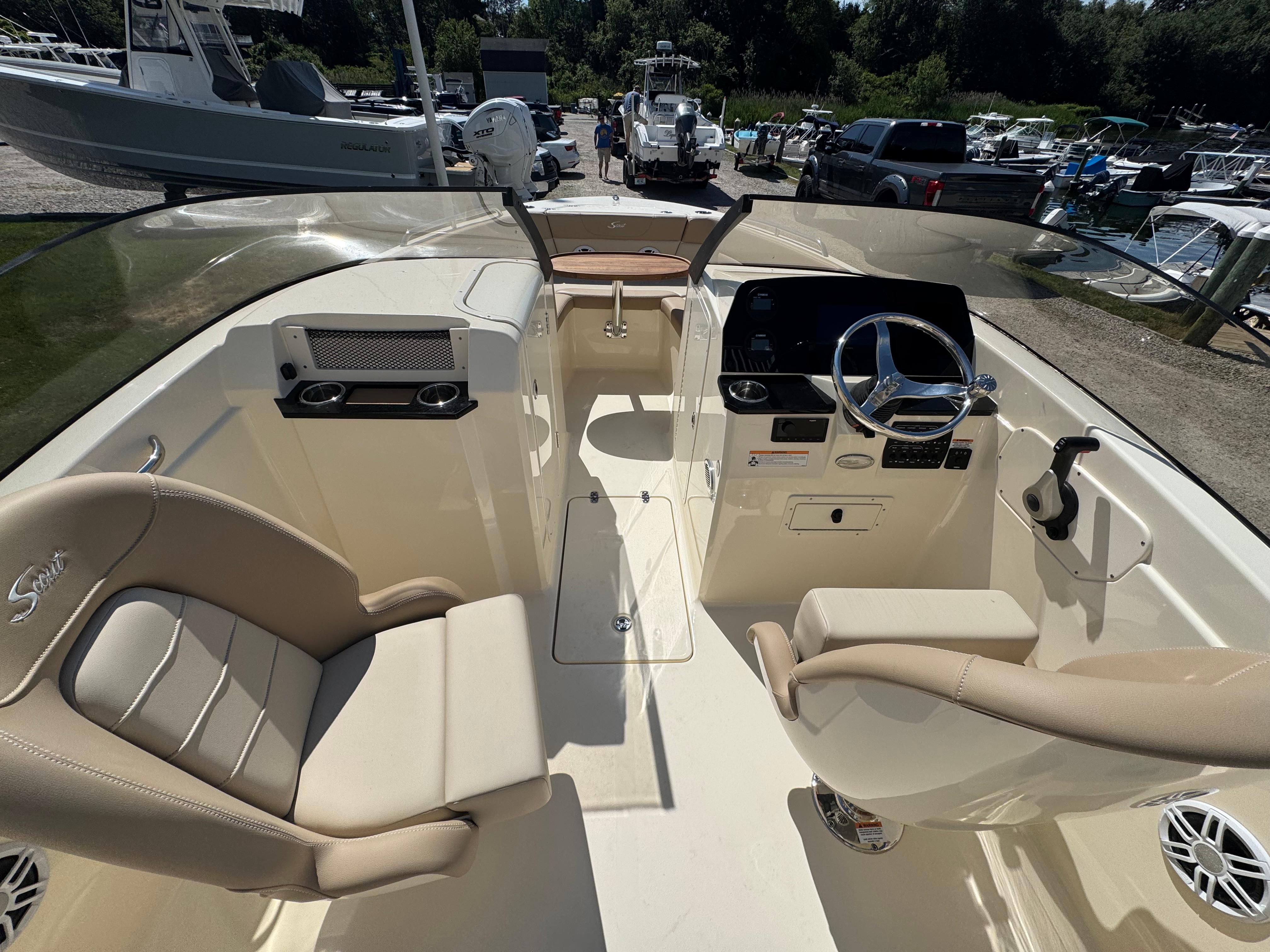 2025 Scout 215 Dorado boat interior with dual seating and steering wheel, docked outdoors.