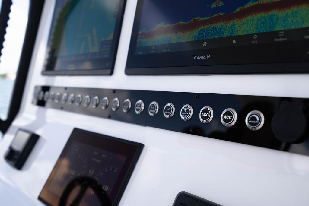 Control panel of 2027 Reef Runner 340 boat with Garmin displays and various switches.