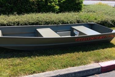 2026 Tracker Grizzly 12 Jon boat on grass, showcasing durable design and compact size.