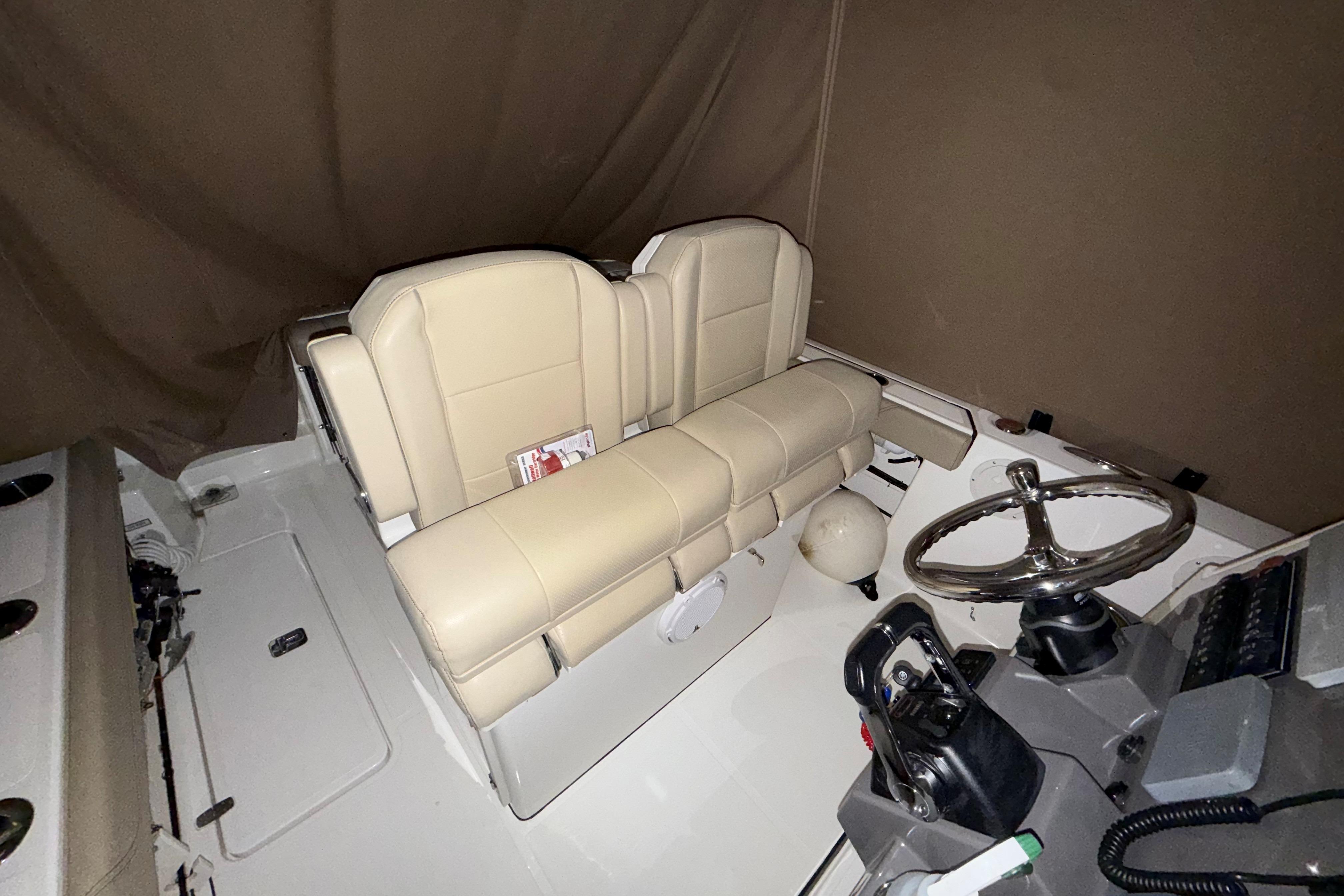 2021 Pursuit S 268 Sport boat interior with beige seating and steering wheel.