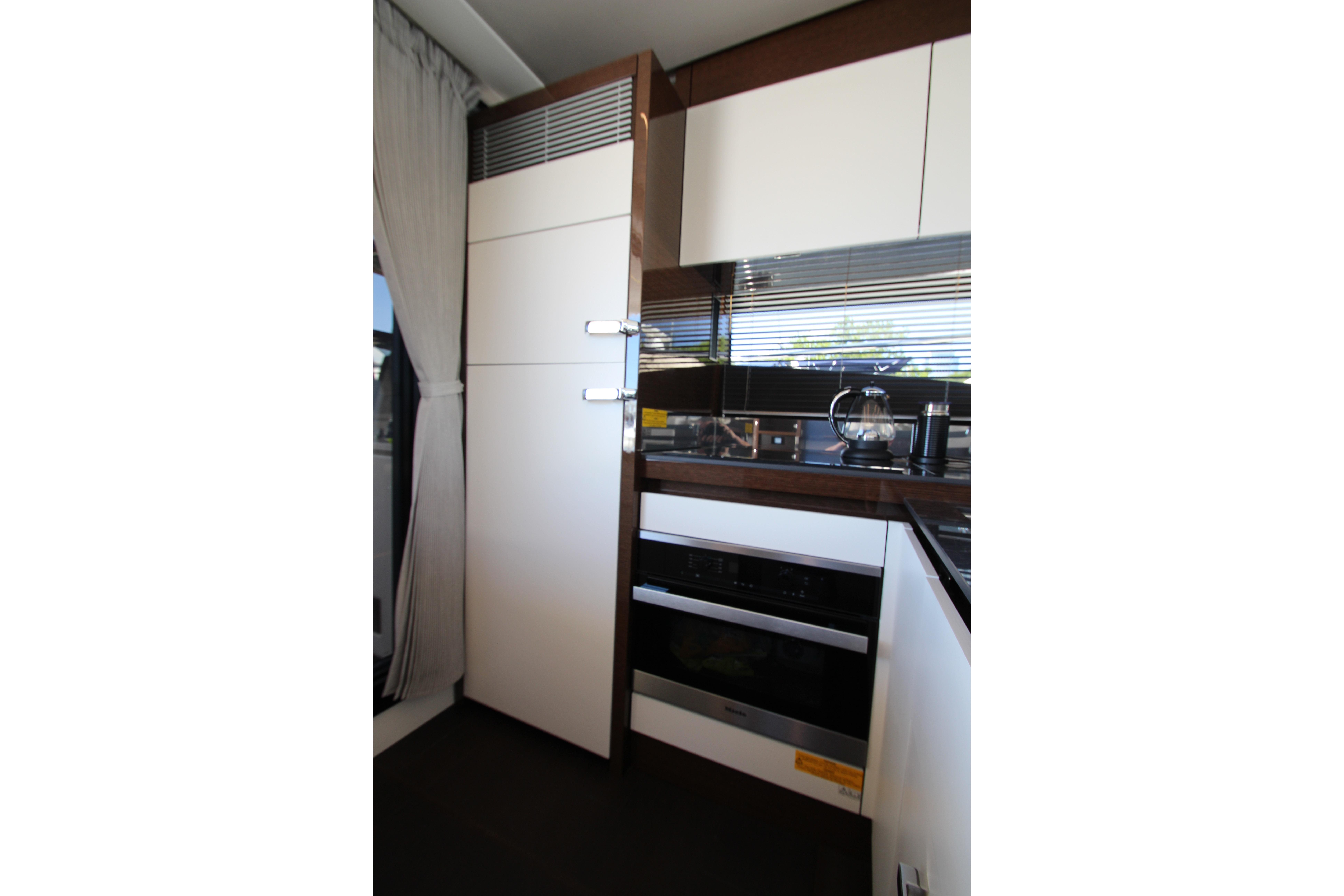 Modern kitchen interior on a 2022 Prestige 520 yacht, featuring sleek cabinetry and appliances.