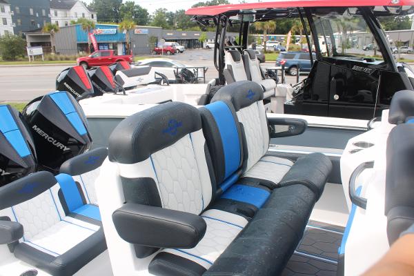 2024 Fountain 34 SC boat interior with blue and white seating, parked outdoors.