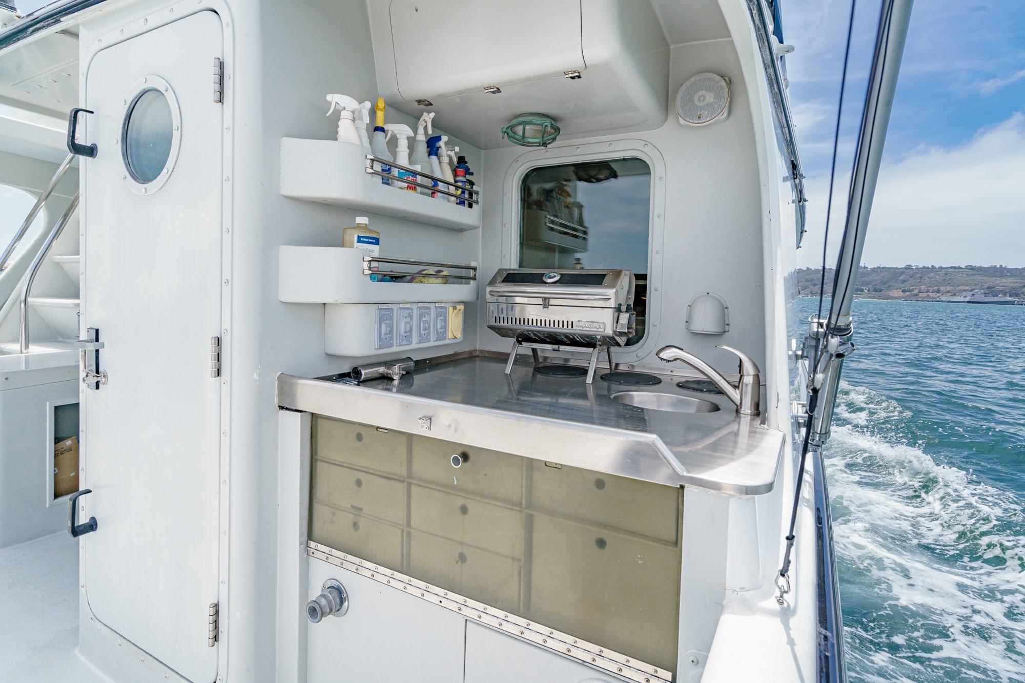 Outdoor kitchen on a 1990 Seaton Long Range Cruiser, featuring a grill and sink.