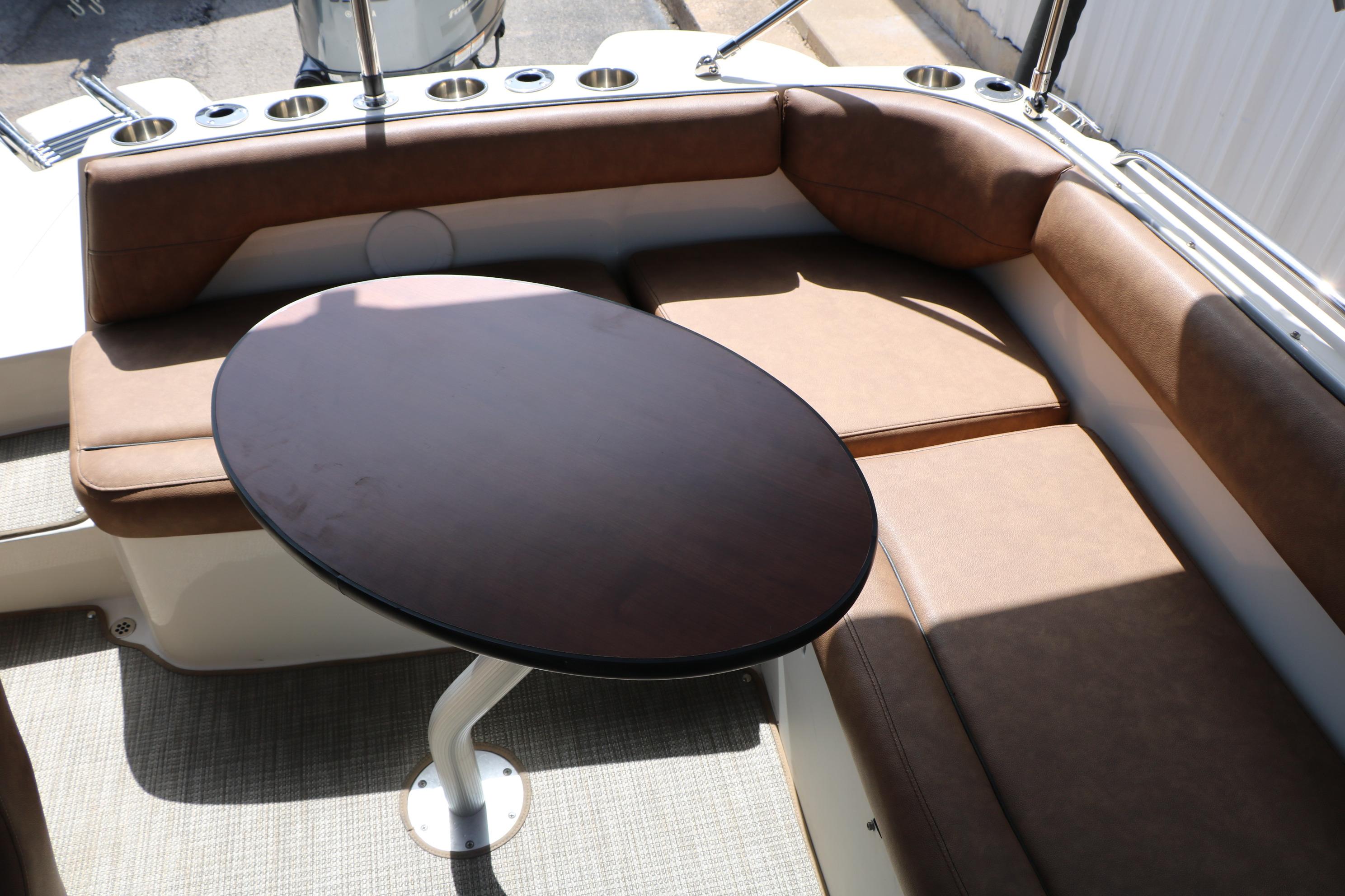 Interior of 2022 Stingray 192 SC boat with brown seating and oval table.