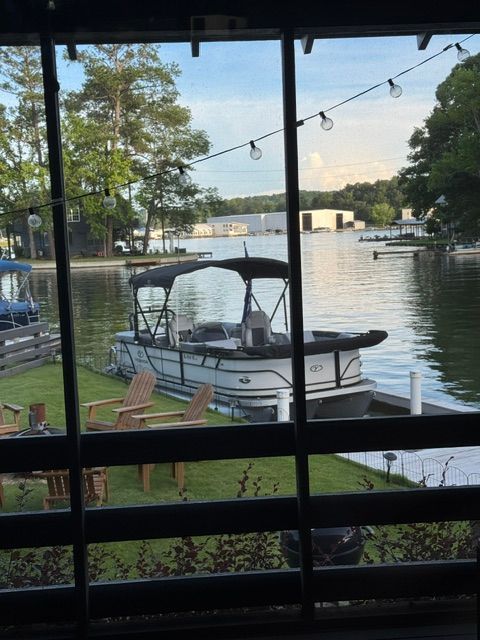 Veranda VR22RC 2021 pontoon boat by lakeside with chairs and string lights.