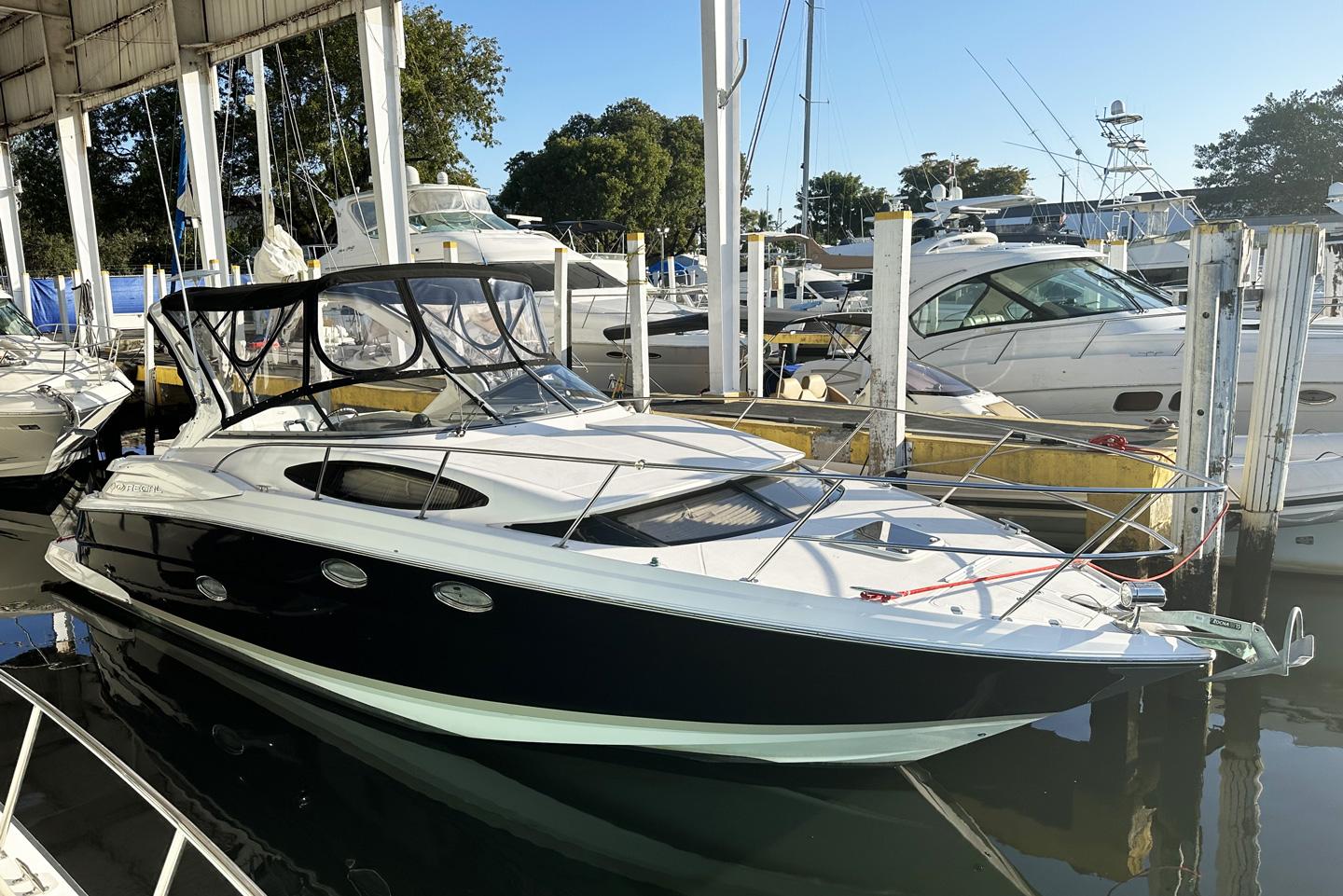 2008 Regal 3360 Window Express boat docked in marina, featuring sleek black and white design.