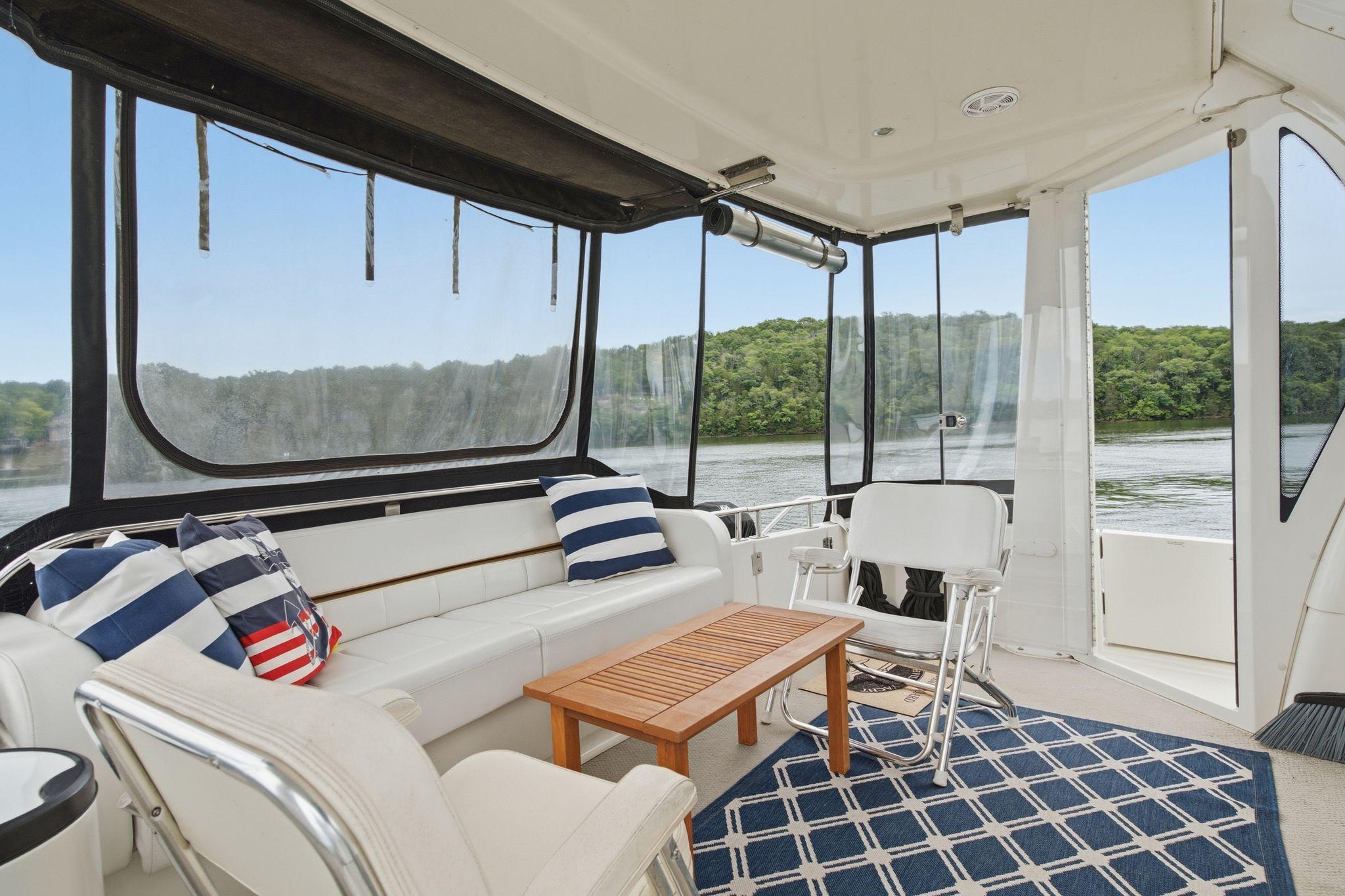 2005 Carver 39 Motor Yacht interior with seating, striped pillows, and scenic water view.