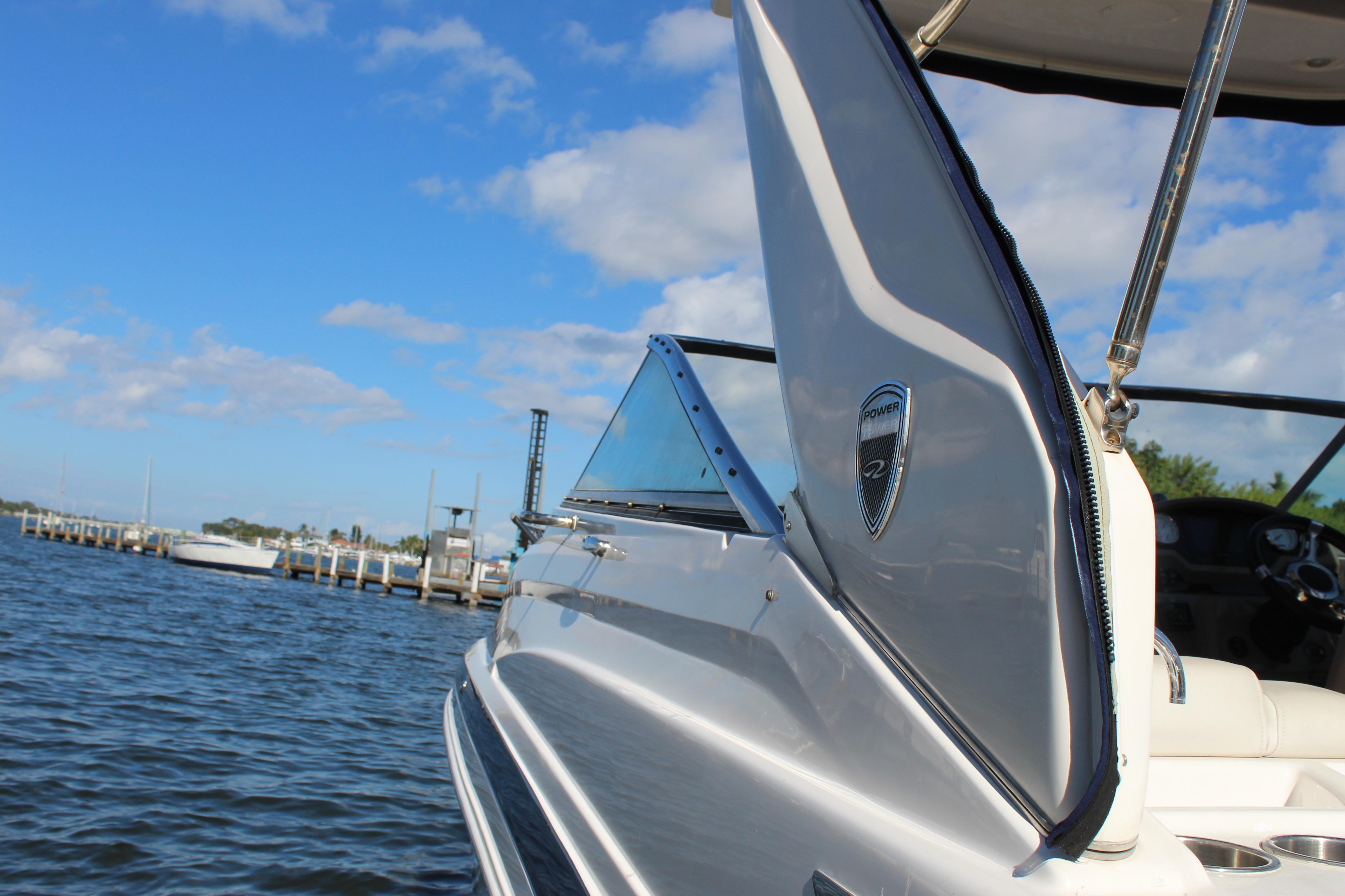 2018 Regal 28 Express boat on water, clear sky, dock in background.