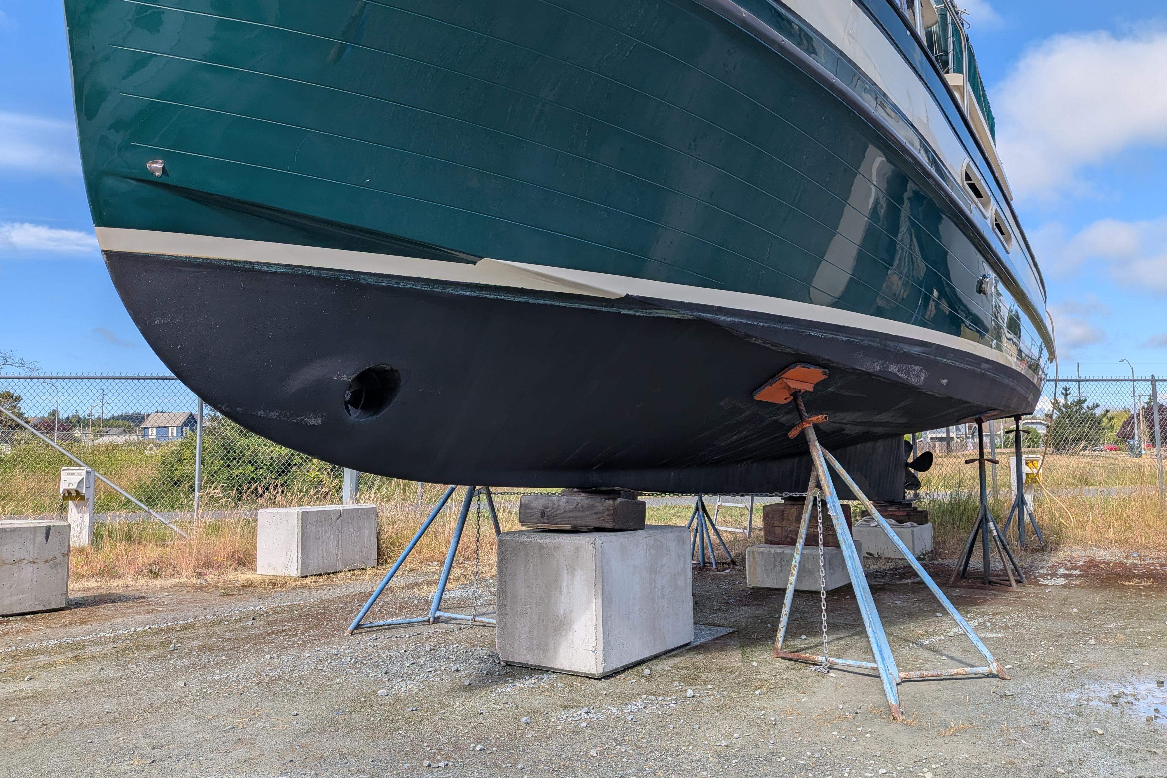 1998 Nordic Tug 32 boat on dry dock, supported by stands, with a green hull.
