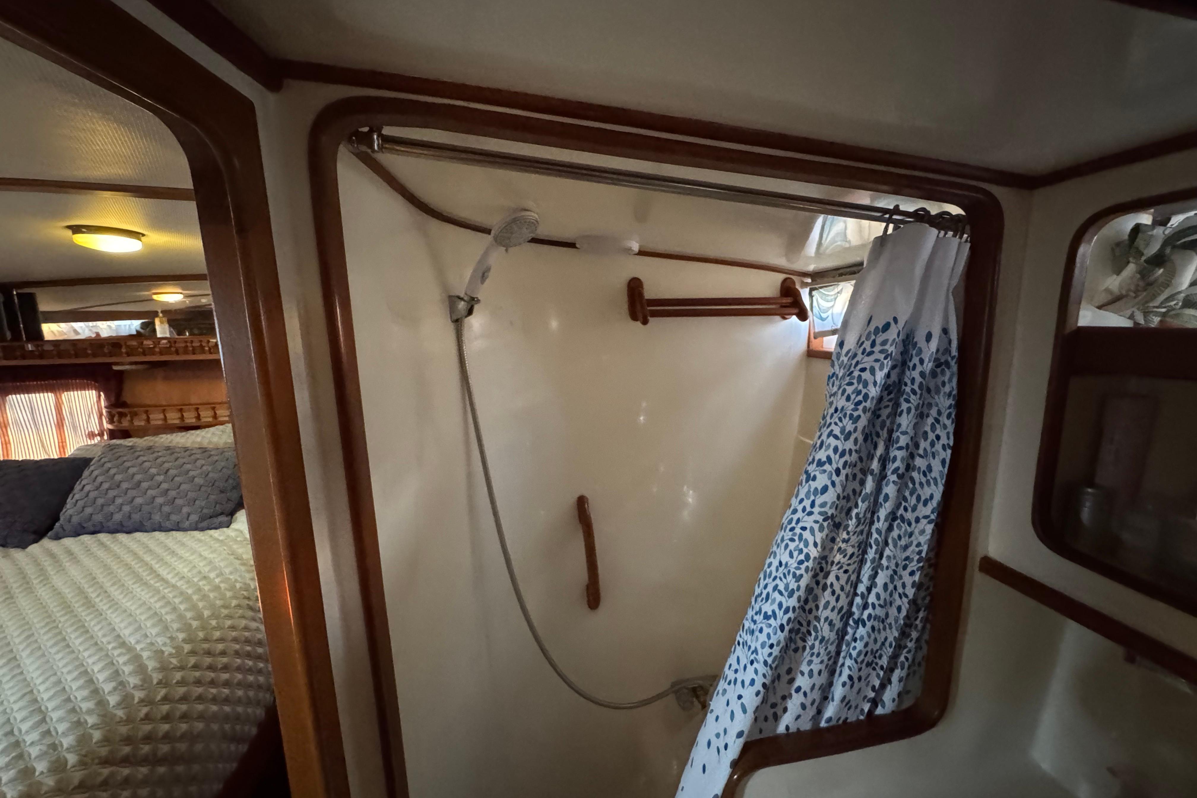 1987 President 37 yacht interior with shower and cozy bedroom view.