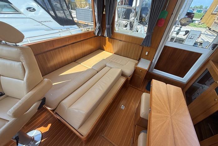 Interior of 2007 Island Pilot 395 yacht with beige leather seating and wooden accents.