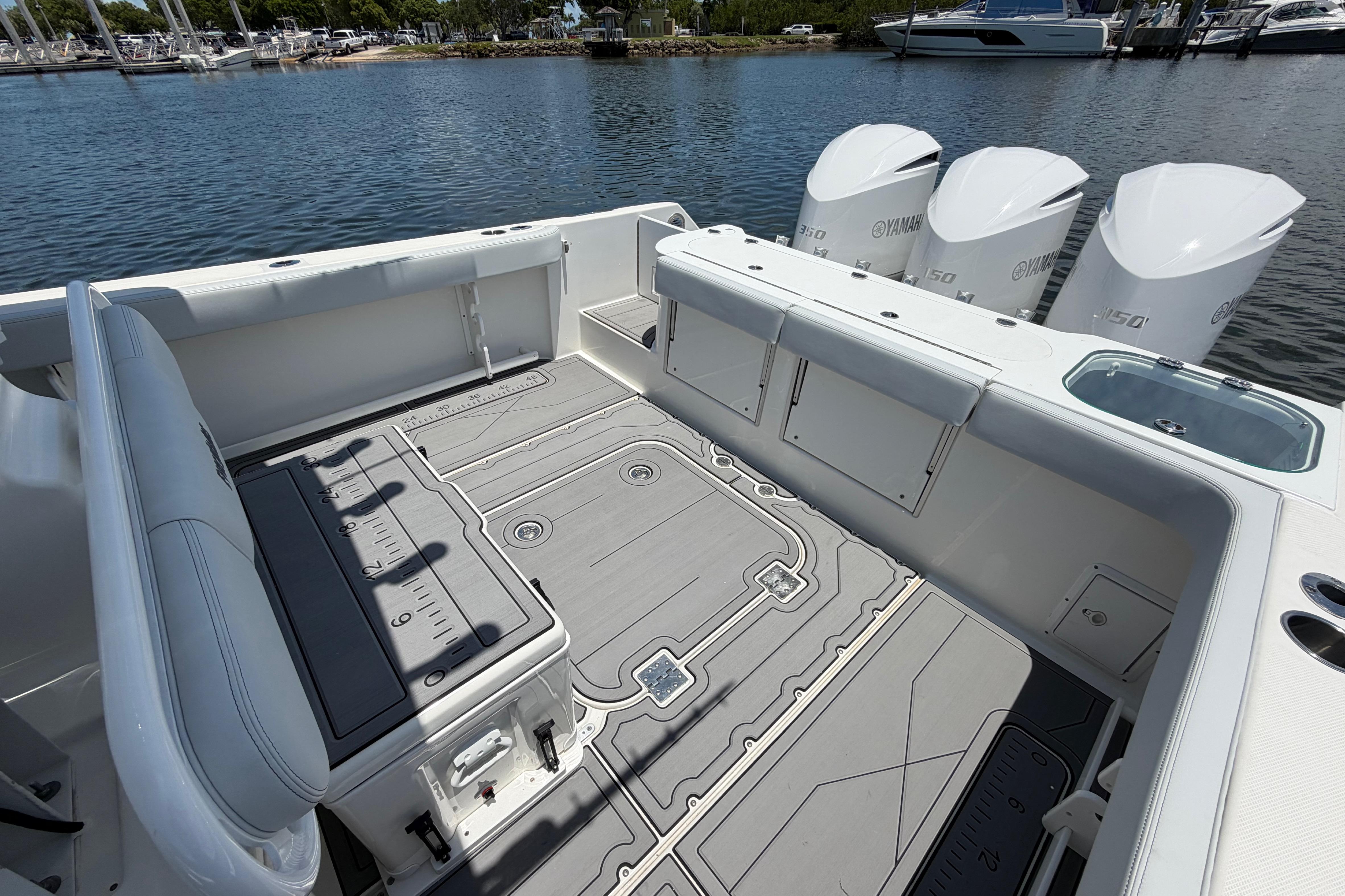 2009 Everglades 350LX boat deck with Yamaha engines, docked by the water.
