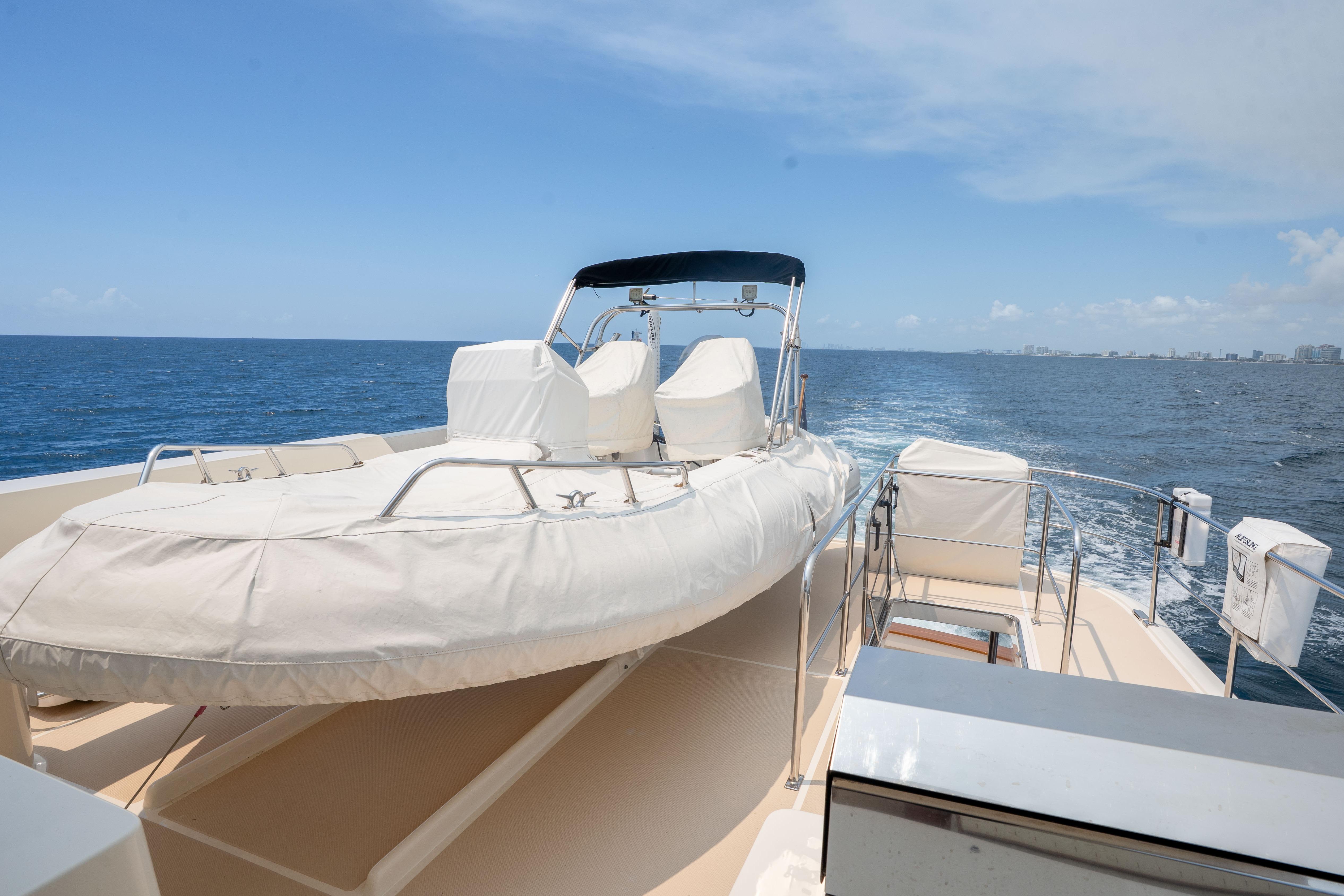 Luxury Fleming 75 yacht deck with covered seating, cruising on open sea, 2006 model.