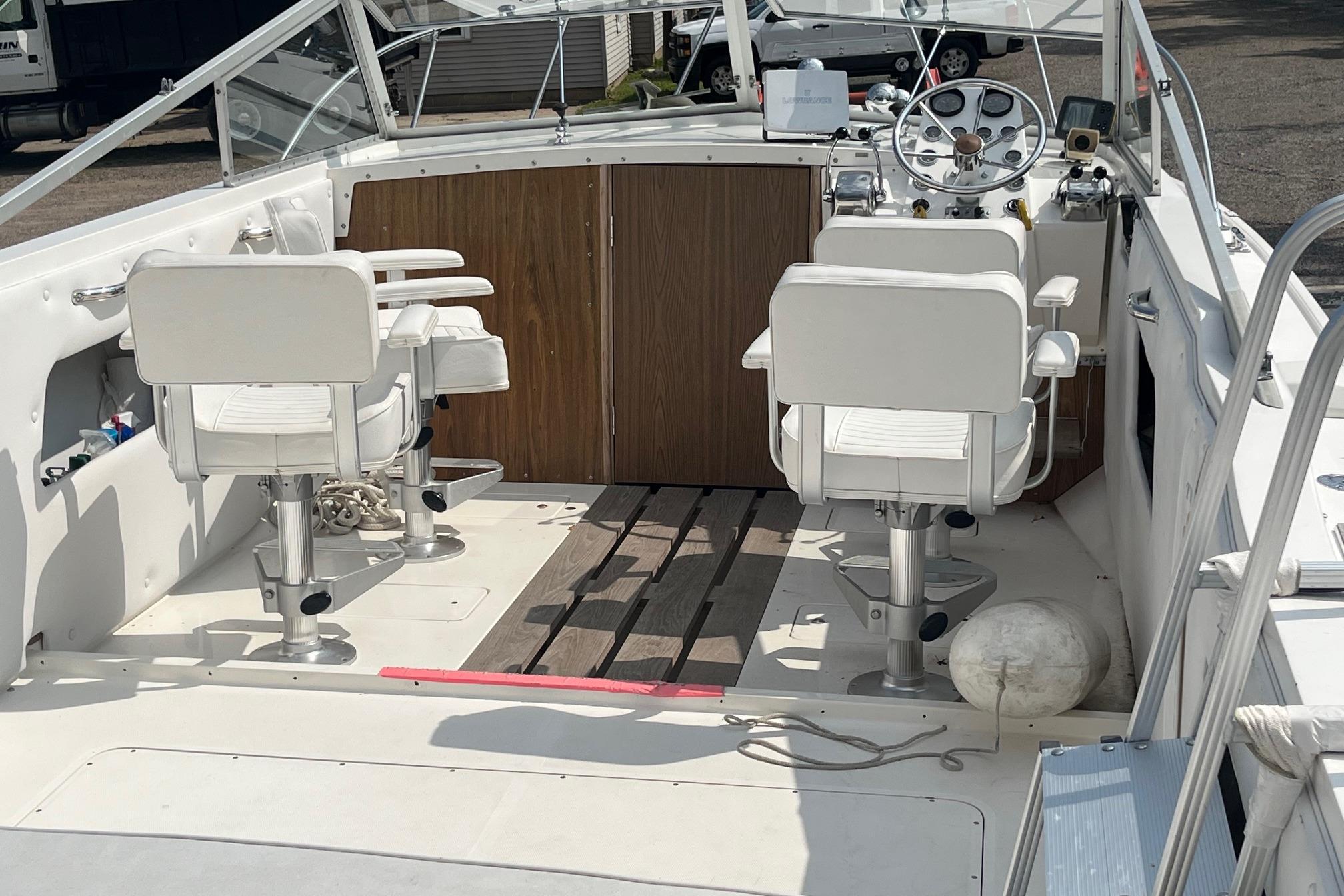 1975 Bertram 26 Moppie boat interior with white seats and wooden accents.