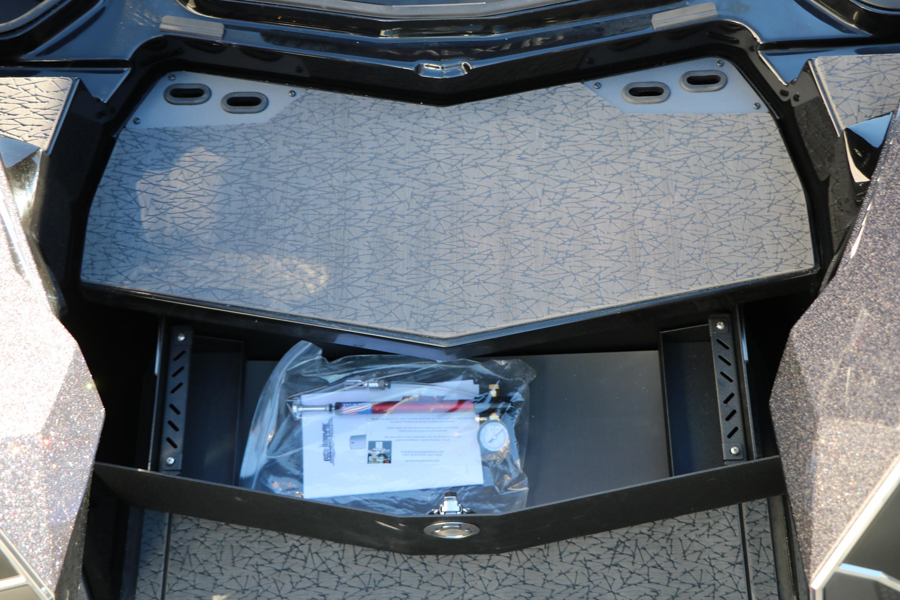 Storage compartment of 2026 Vexus VXs21 boat with accessories and manual.