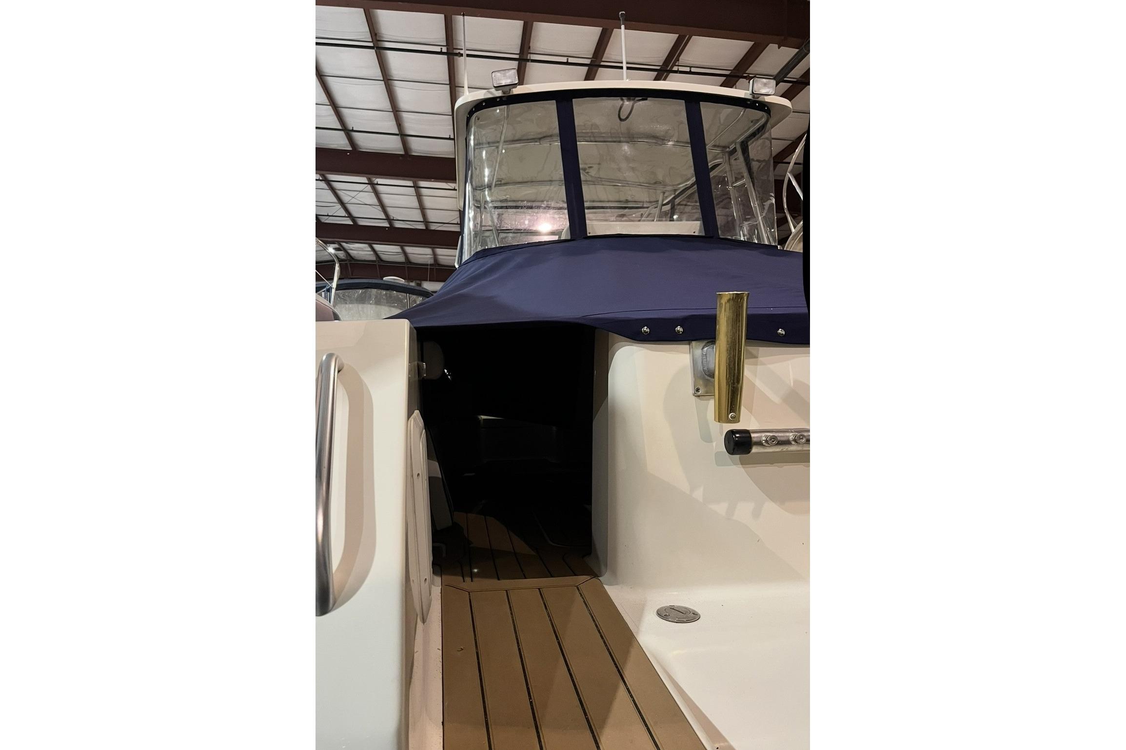 2000 Pursuit 3070 Offshore Center Console boat with blue cover in storage.
