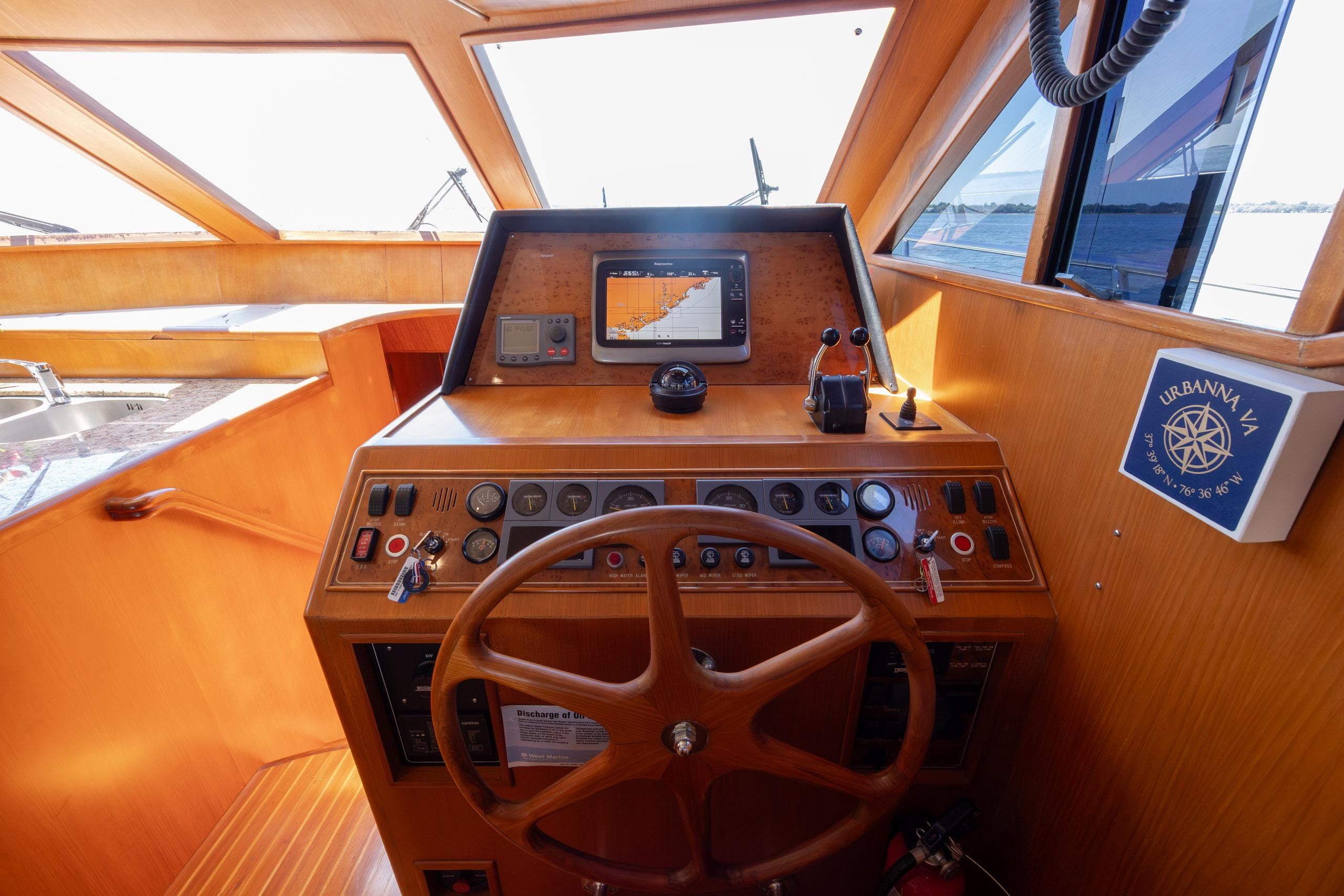 Helm of 2005 Ocean Alexander 52 Sedan yacht with navigation equipment and wooden steering wheel.